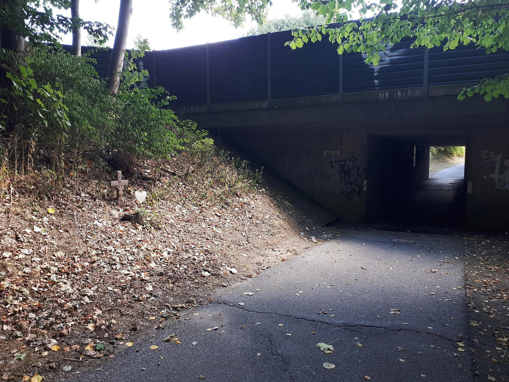 Photo showing: Ausgang des Fußgängertunnels zum Stadtweg. An der linken Seite erinnert ein Kreuz an Insassen, die an dieser Stelle am 6. Oktober 2013 mit ihrem Ultraleichtflugzeug verunglückten.