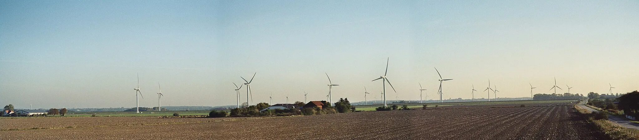 Photo showing: Im südlichen Ende der Gemeinde Reußenköge stehen aufgereiht mehrere Reihen von Windenergieanlagen unterschiedlicher Windparks. Die Sichtachse erfolgt hier vom Deich des Cecilienkoogs (Aufnahmestandort) in Richtung Osten