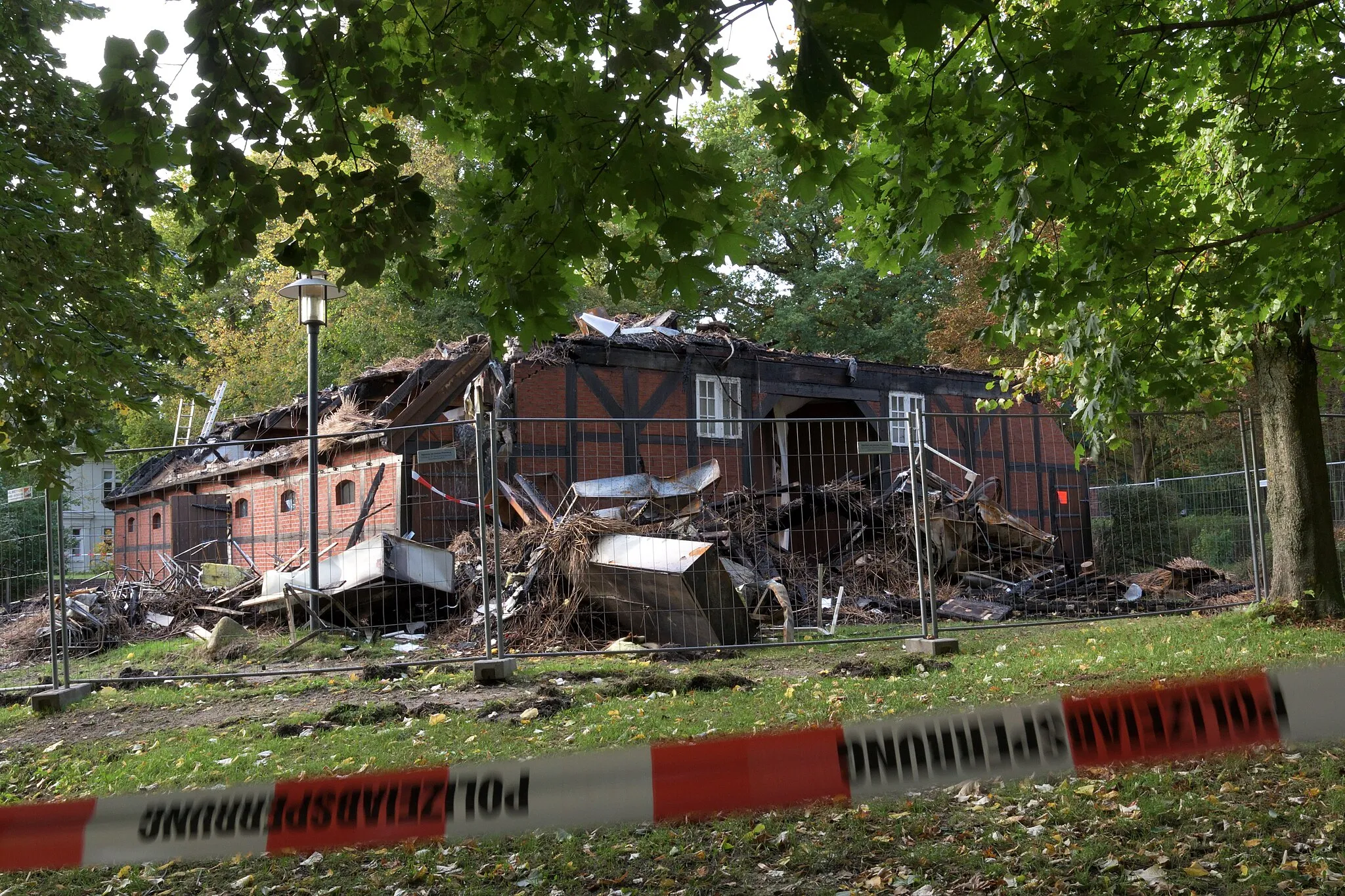 Photo showing: Remains of the museum barn from 1762 of the Museum Langes Tannen, Uetersen (Kreis Pinneberg), Germany, burnt down by arson on 10 October 2021. View from south east. The fire site was seized and cordoned off by the police at the day the photo was taken, 16 October 2021.