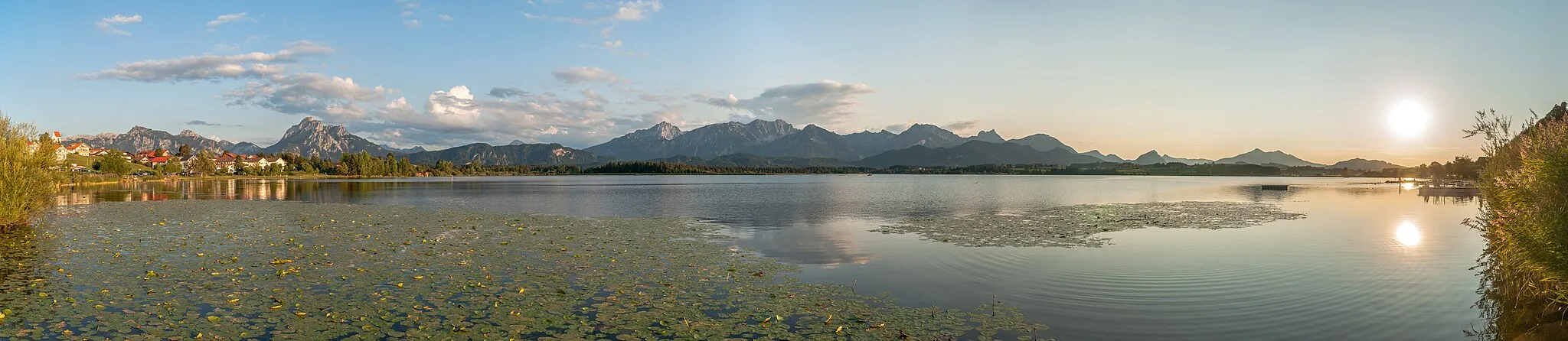 Photo showing: Lake Hopfensee with village 'Hopfen am See', Ammergauer Alps (left) and Allgäuer Alps in the evening sun, Bavaria/Germany.