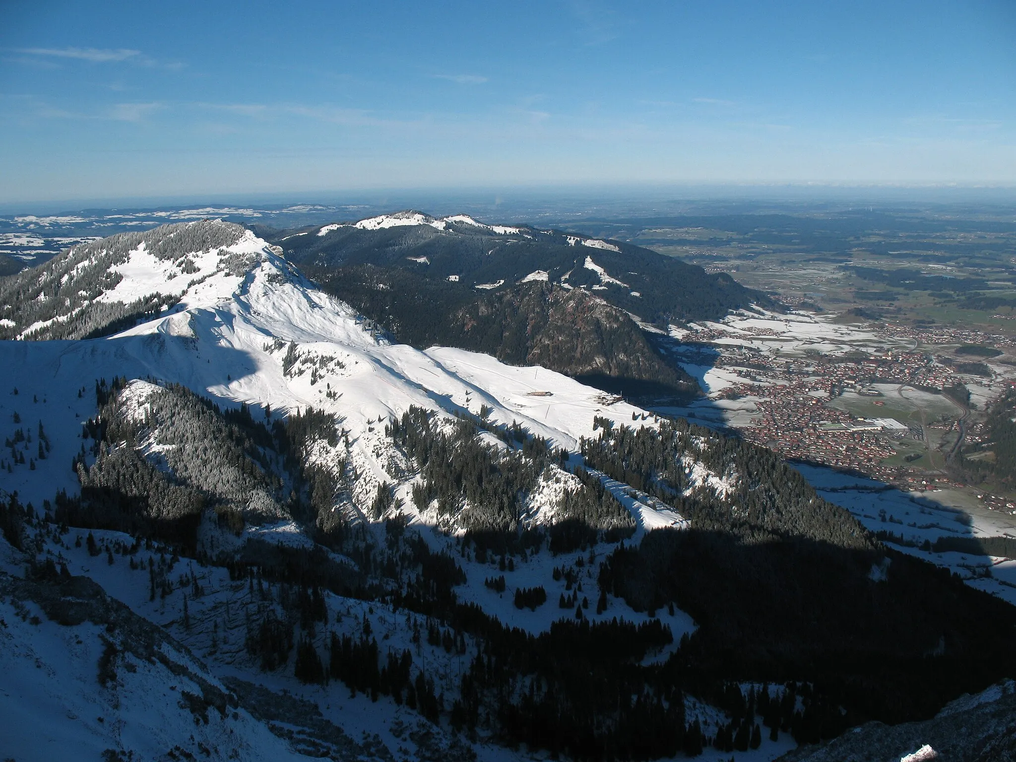 Photo showing: Breitenberg (1838 m, Tannheimer Berge) mit Skigebiet und Pfronten (853 m) gesehen vom Brentenjoch (2000 m). Ein wenig niedriger: Edelsberg und Alpspitz, dazwischen Kienberg mit Pfrontener Berg.