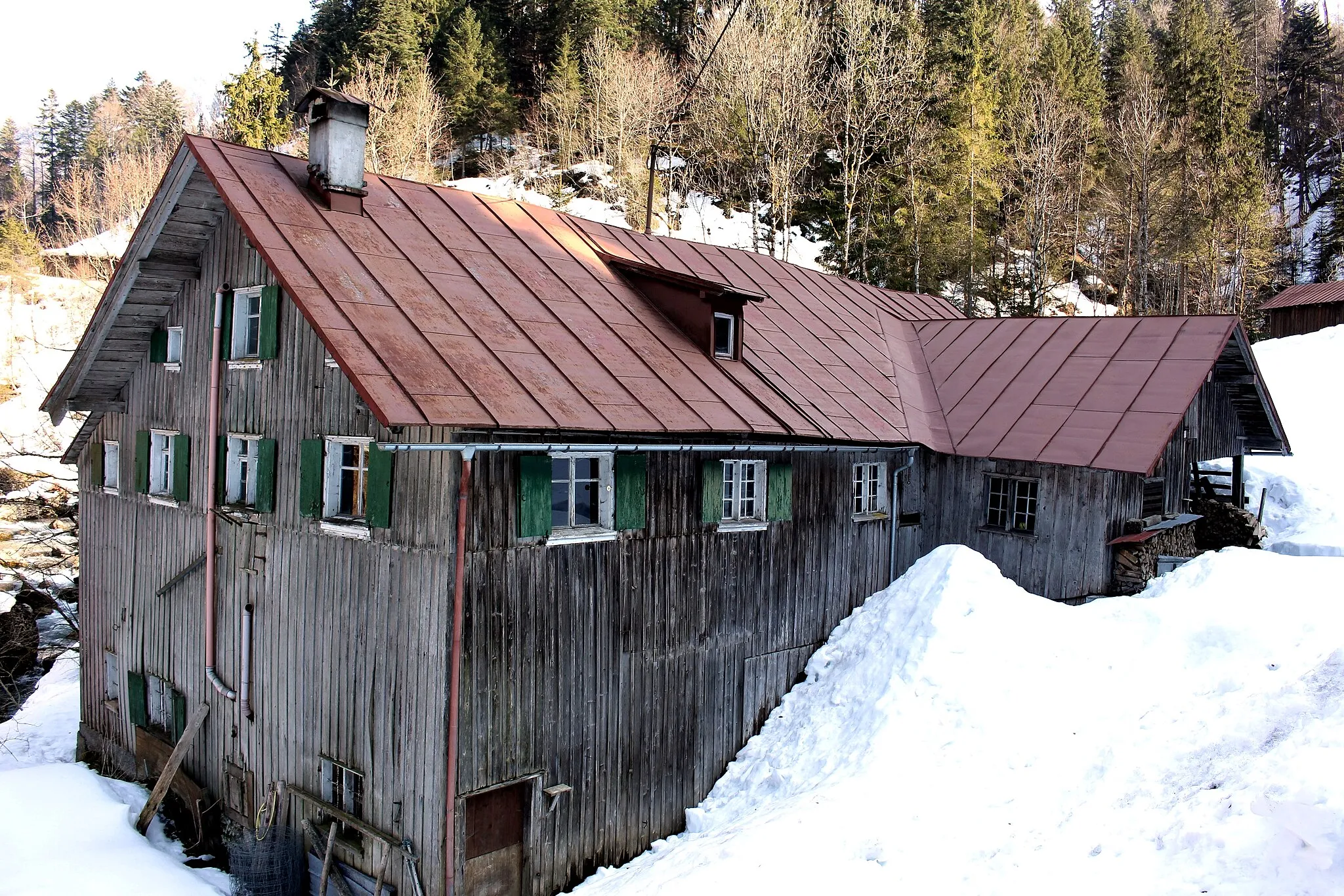 Photo showing: Oberstaufen, OT Steibis, Lanzenbach 1, Lanzenbachsäge. Das ehemalige Sägewerk, ein zweigeschossiger, verschalter Blockbau mit Satteldach und oberschlächtigem Wasserrad, stammt aus der ersten Hälfte des 19. Jahrhunderts.