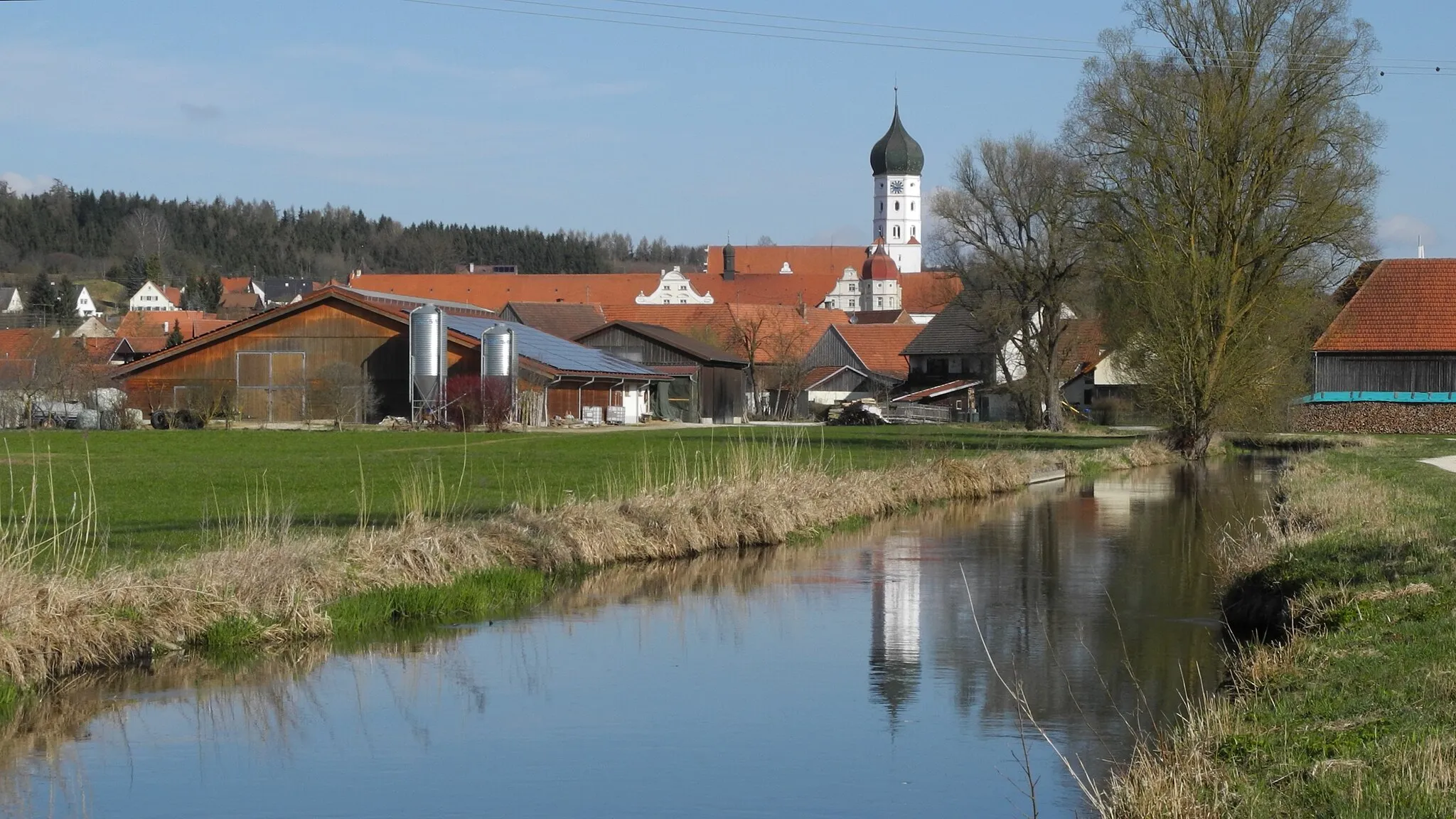 Photo showing: Wettenhausen aus südlicher Richtung, mit dem von der Kammel abzweigenden Mühlkanal; im Hintergrund Kloster Wettenhausen