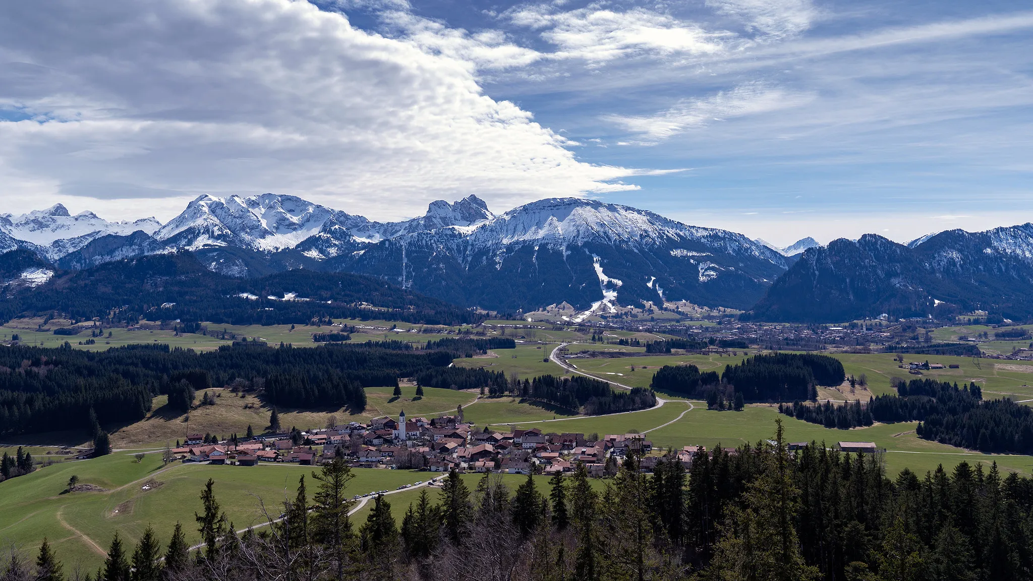 Photo showing: 500px provided description: The view over the region Allg?u in southern Germany near the city Eisenberg. [#trees ,#sky ,#landscape ,#forest ,#clouds ,#germany ,#village ,#mountain ,#hill ,#alps ,#scenery ,#rural scene ,#mountain peak ,#mountain range ,#allg?u ,#snowcapped ,#rolling landscape ,#eisenberg ,#a7iii]