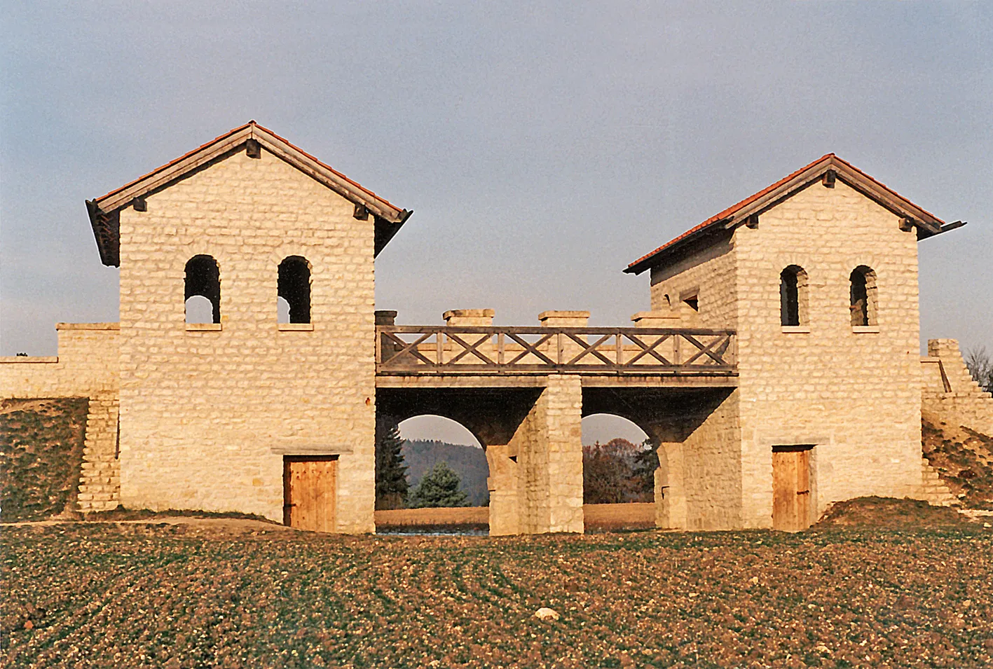 Photo showing: Kastel Pfünz, Bayern: Ein für die frühen 1990er Jahre idealtypischer Rekonstruktionsversuch der Porta praetoria auf den antiken Fundamenten. Blick vom Lagerinneren auf das Tor. Schon früh galt diese Rekonstruktion als veraltet. Sie ist um ein Stockwerk zu niedrig. Zustand im Januar 1993.