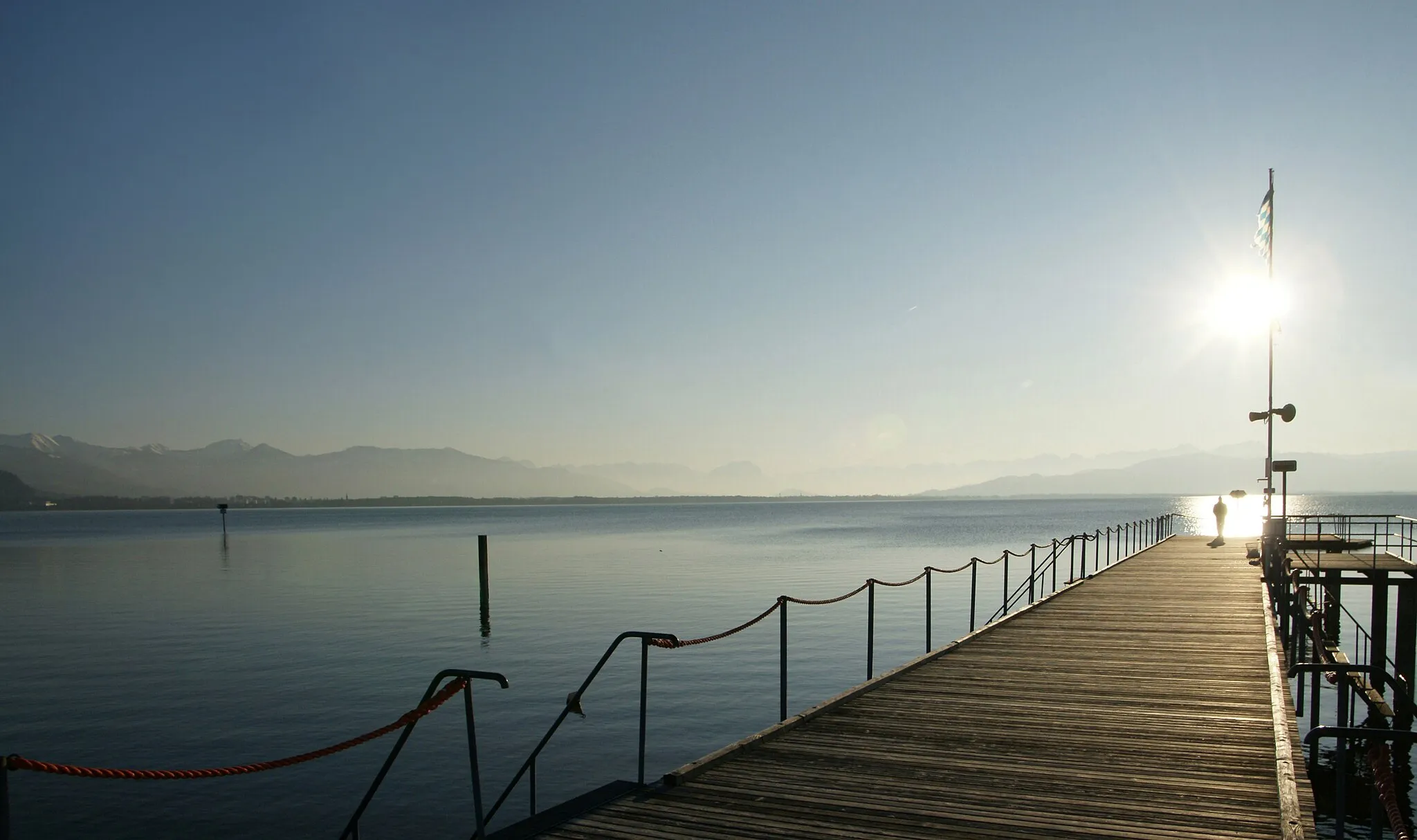 Photo showing: Steg am Strandbad von Lindau am Bodensee. Am Bildrand mit Schnee bedeckt das Bregenzerwaldgebirge mit der Dornbirner Firstkette und dem Karrenberg.