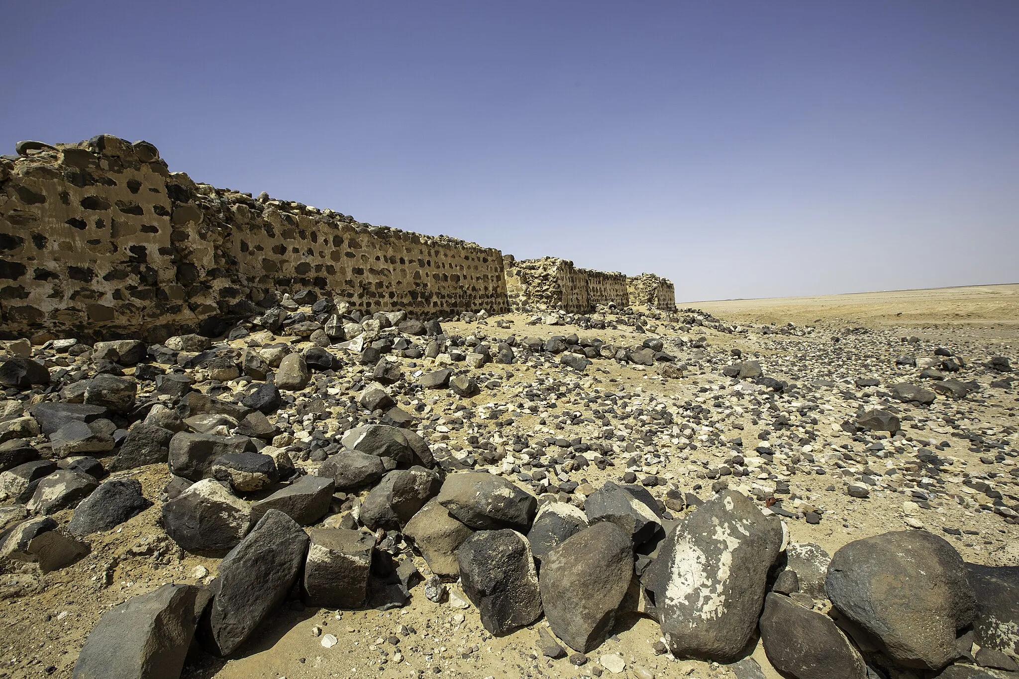 Photo showing: Das Kastell Dajaniya, ein spätrömisches Militärlager nahe der modernen Siedlung Al-Husseiniyeh, einer Ortschaft im Gouvernement Ma'an in Südjordanien. Blick von Osten auf einen Abschnitt der nordöstlichen Umfassungsmauer.