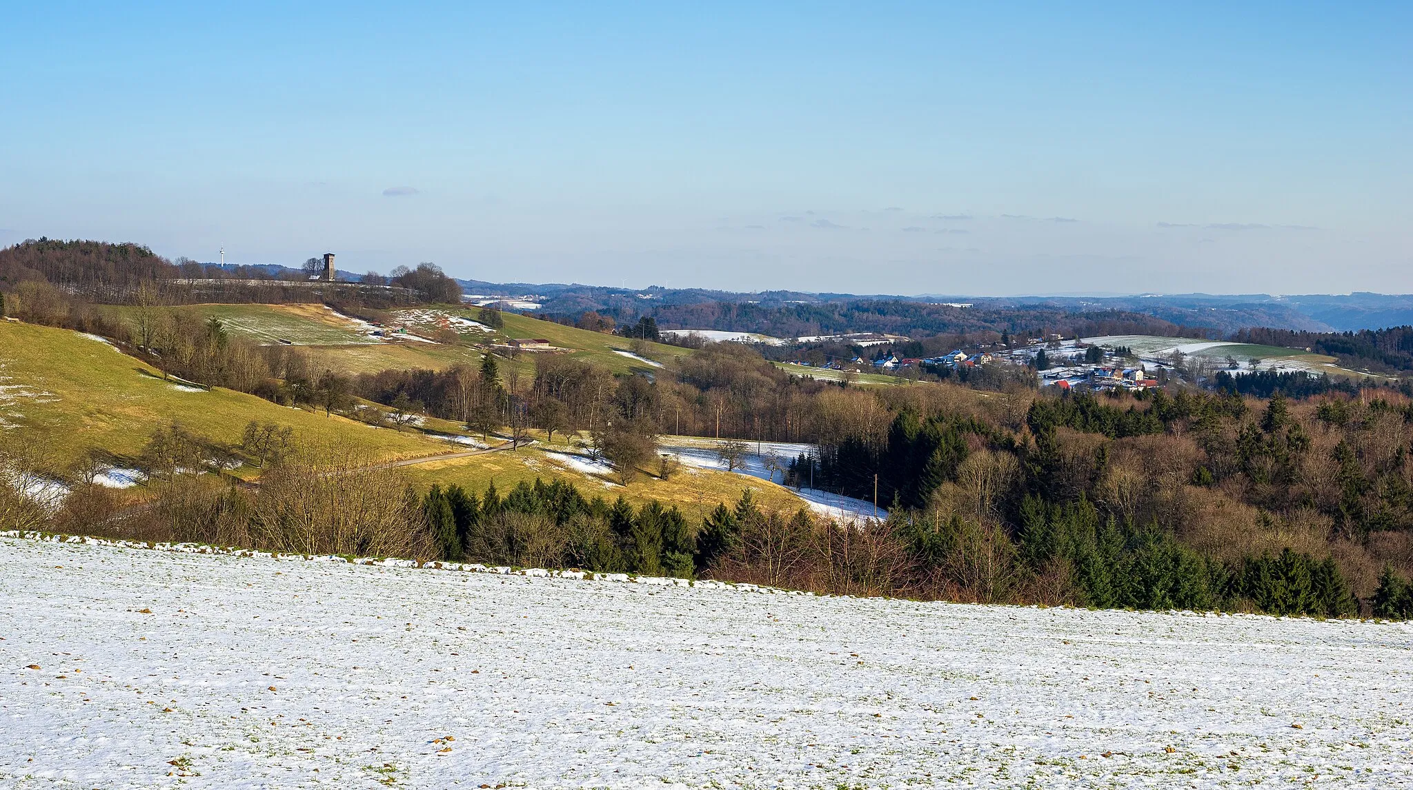 Photo showing: Winter landscape in the proteced landscape area “Spiegelberger Lautertal mit Nebentälern und angrenzenden Gebieten” (Baden-Württemberg, Germany, local ID 1.19.044, WDPA ID 324223). View from the hill above Nassach (a district of Spiegelberg towards east by south-east over wide parts of the Lautertal. At the left, the Juxkopfturm (observation tower), right of the centre the village Jux, in the background the elevations and hamlets of the Swabian-Franconian Forest.