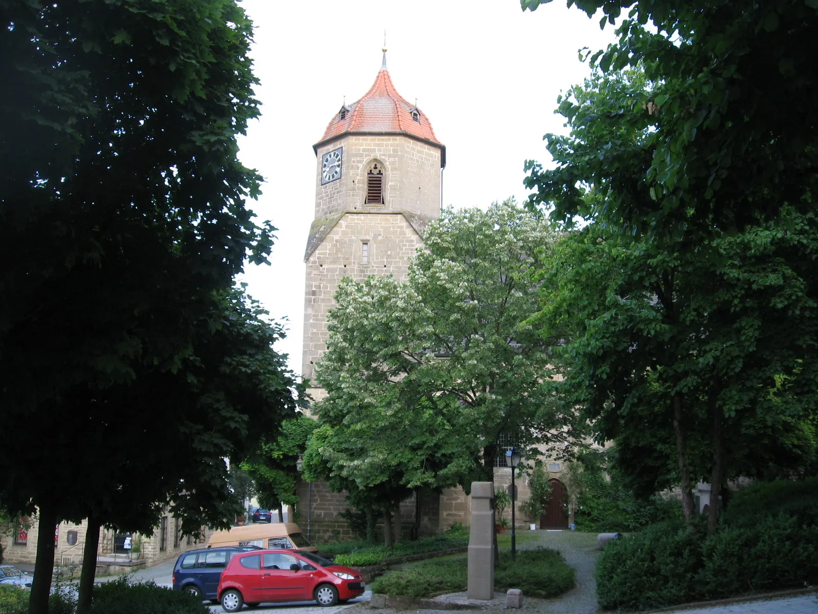 Photo showing: Blick im Sommer vom Eingang des Obersontheimer Schlosses auf die evangelische Pfarrkirche des Ortes, davor das Schubartdenkmal.