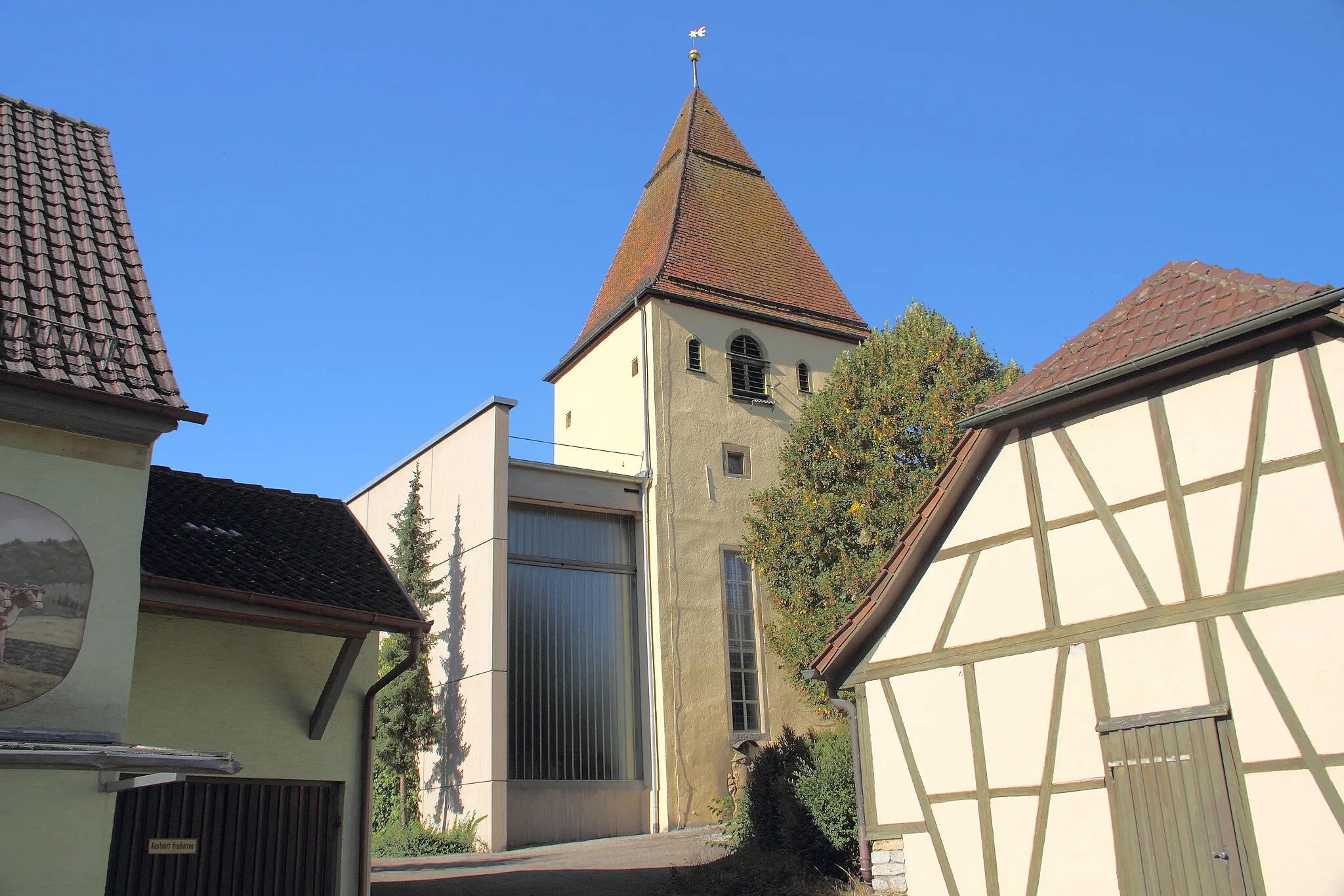Photo showing: Die evangelische Pfarrkirche des Niederstettener Ortsteils Vorbachzimmern steht gem. §28 DSchG unter Denkmalschutz. Der alte frühgotische Turm ist in einen Neubau aus dem Jahr 1967 integriert. Auch im Innern ist der alte Turm deutlich vom modernen Inneren abgegrenzt.