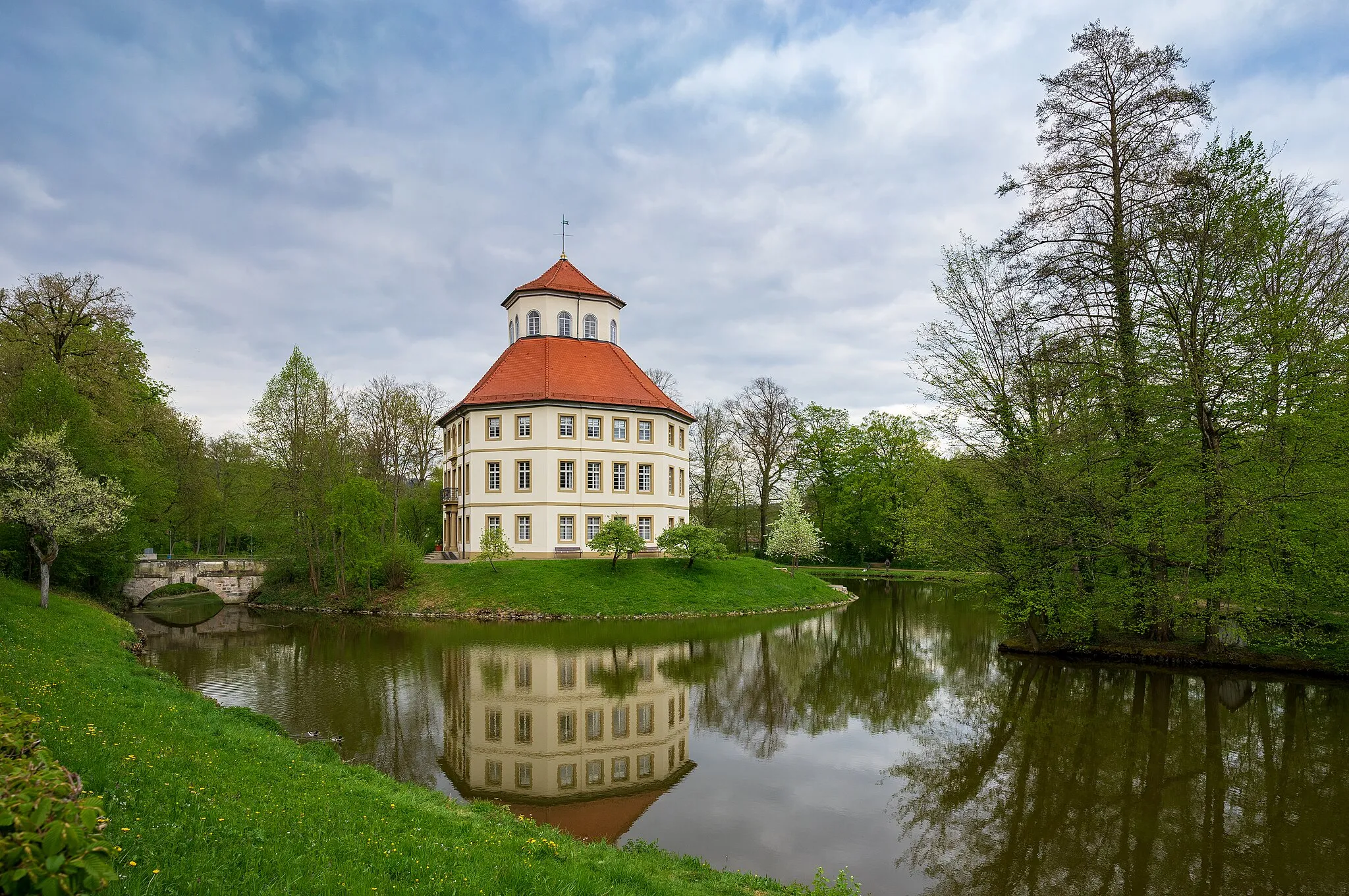 Photo showing: Oppenweiler, Germany: The octogonal residential castle set on a lake, built in 1782, today the townhall. Seen from south south-west from the castle gardens which were laid out at the same time. At the left you can see the bridge which is the only access to the castle.