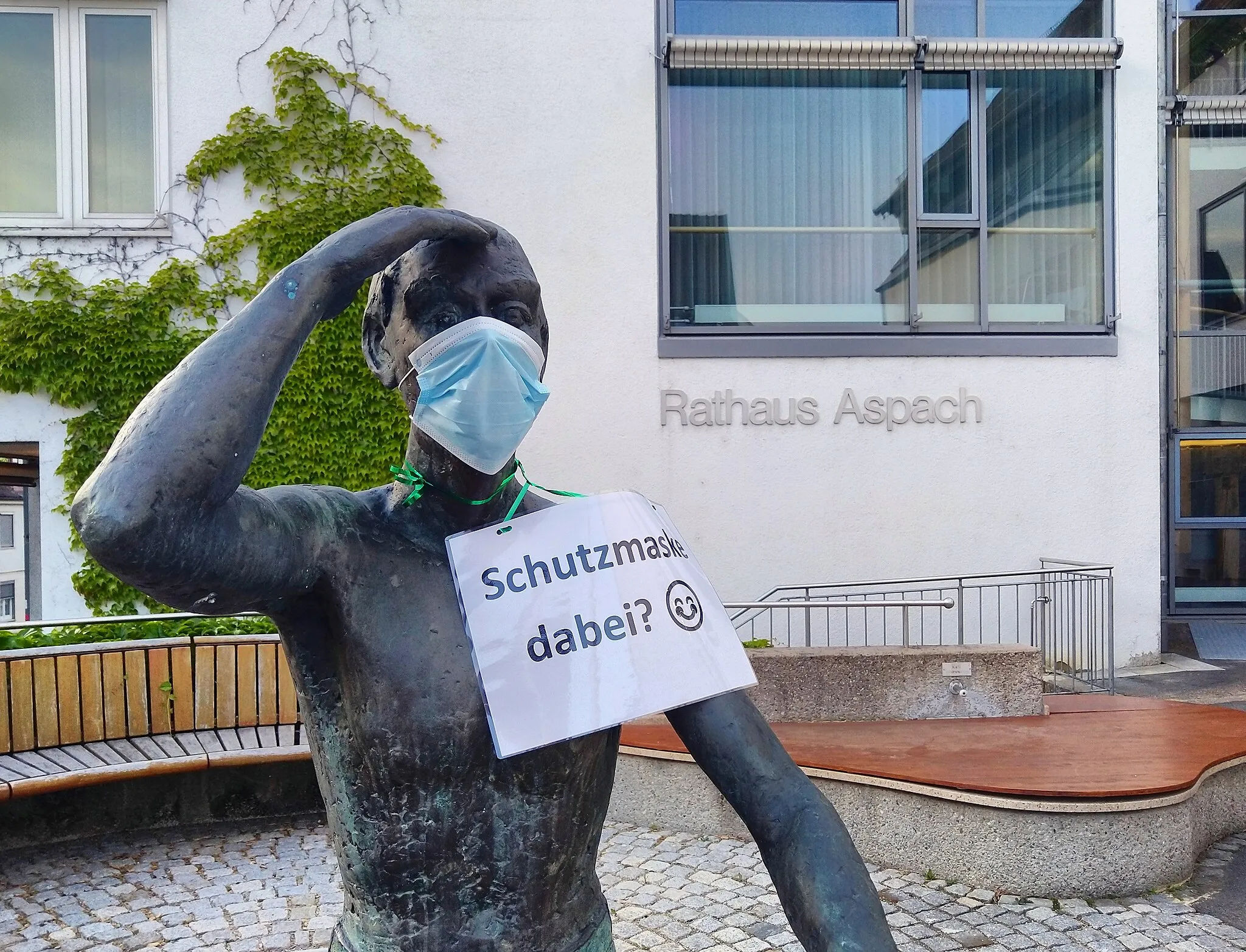Photo showing: Bronze statue in front of the town hall in Aspach wears a mouth-and-nose protection to remind visitors of wearing the protective mask in the town hall.
