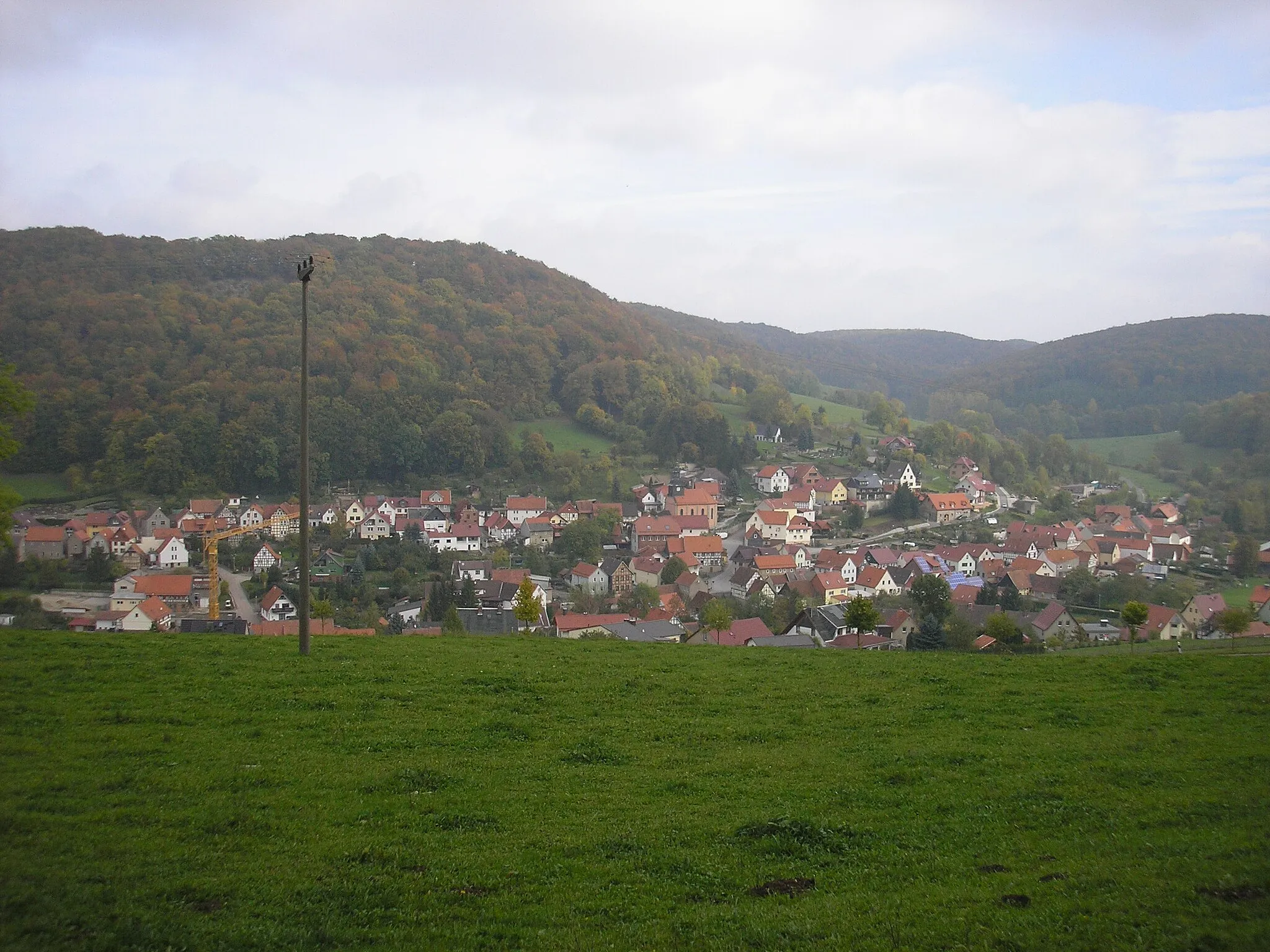 Photo showing: Blick über Faulungen im Südeichsfeld (Thüringen), im Hintergrund der Schlegelsberg (li mit dem Faulunger Stein) und der Pfaffenkopf (re).