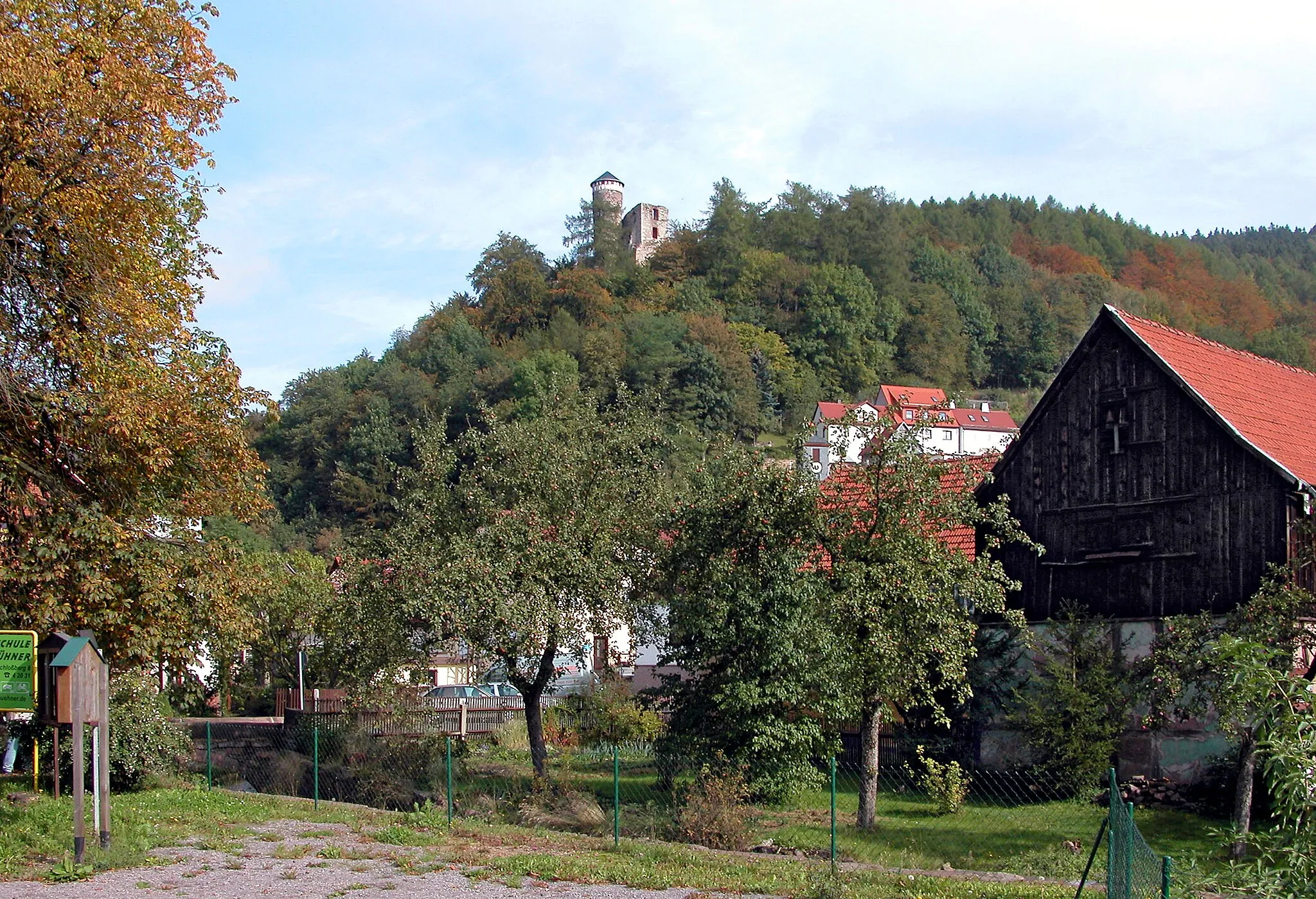 Photo showing: 03.10.2004  98587  Steinbach-Hallenberg: Blick zur Ruine der Hallenburg (GMP: 50.706438,10.572693). Die Erbauungszeit 909 ist umstritten, Entstehungszeit vermutlich nach 1212. 1245 genannt. Alternativname(n): castum Haldenberc (1268), Haldenberg (1360, 1420), Haldenburg (1391), Schloß Hallenbergk (1532), Hauß Hallenbergk (1565), Schloß Hallenburgk (1607), Hauß Hallenburgk (1616). Die Hallenburg liegt auf einem etwa 80m hohen, nach drei Seiten hin steil abfallenden Porphyrfelsen am Arnsberg. Nach wechselnden Besitzverhältnissen wurde 1608 das ruinöse Haus Hallenberg mit allen seinen Gebäuden niedergelegt. Seitdem war die Burg Ruine. Erst im 19. Jahrhundert bemühte man sich wieder um ihre Erhaltung. Seit 1984 bekrönt wieder eine Dachhaube nach altem Vorbild den Turm. Der heute als Ruine erhaltene Teil der Burg stellt das sogenannte "Oberhaus" dar.                                                                                                       [DSCN5543.JPG]20041003100DR.JPG(c)Blobelt