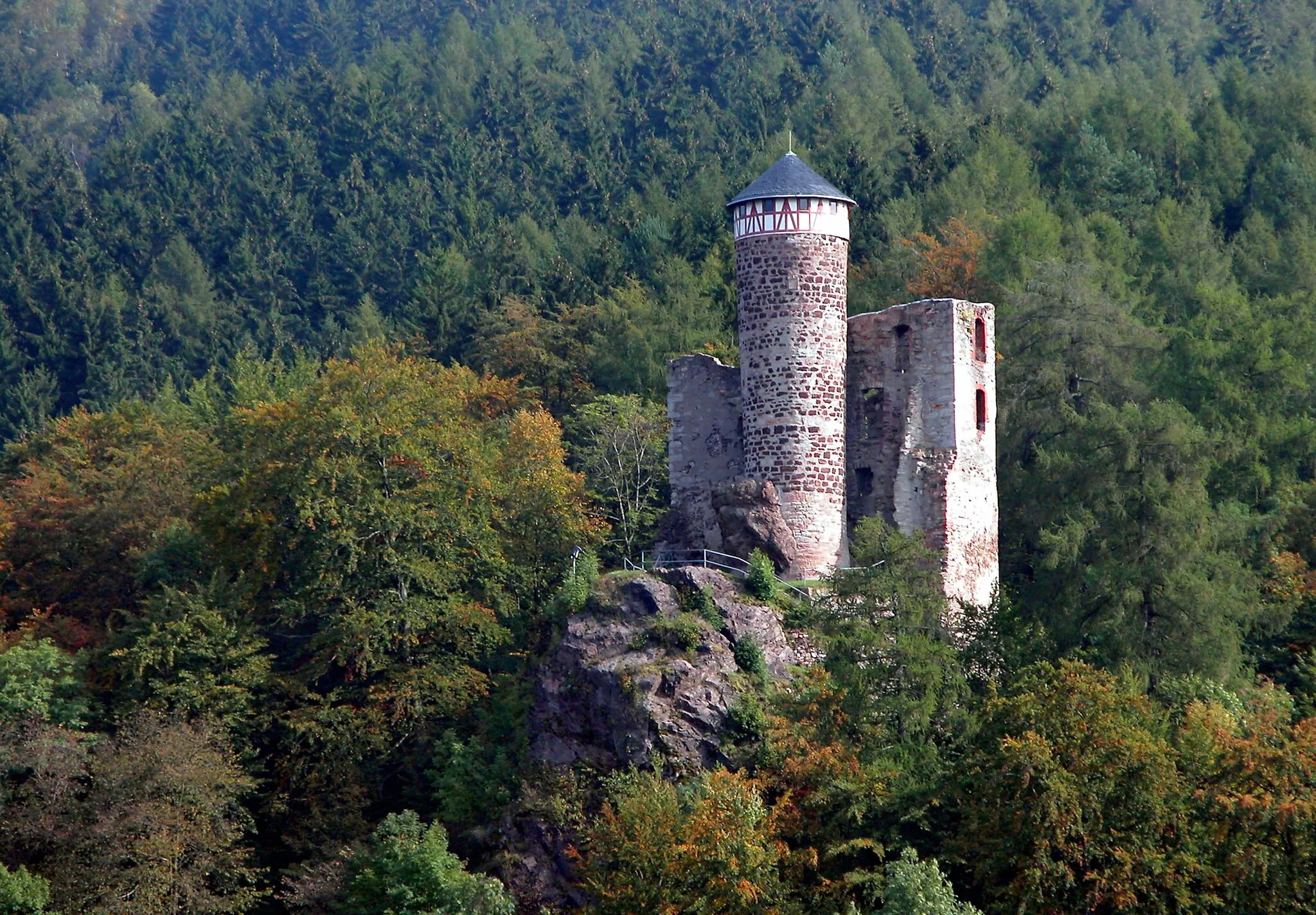 Photo showing: 03.10.2004  98587  Steinbach-Hallenberg: Ruine der Hallenburg (GMP: 50.706438,10.572693). Die Erbauungszeit 909 ist umstritten, Entstehungszeit vermutlich nach 1212. 1245 genannt. Alternativname(n): castum Haldenberc (1268), Haldenberg (1360, 1420), Haldenburg (1391), Schloß Hallenbergk (1532), Hauß Hallenbergk (1565), Schloß Hallenburgk (1607), Hauß Hallenburgk (1616). Die Hallenburg liegt auf einem etwa 80m hohen, nach drei Seiten hin steil abfallenden Porphyrfelsen am Arnsberg. Nach wechselnden Besitzverhältnissen wurde 1608 das ruinöse Haus Hallenberg mit allen seinen Gebäuden niedergelegt. Seitdem war die Burg Ruine. Erst im 19. Jahrhundert bemühte man sich wieder um ihre Erhaltung. Seit 1984 bekrönt wieder eine Dachhaube nach altem Vorbild den Turm. Der heute als Ruine erhaltene Teil der Burg stellt das sogenannte "Oberhaus" dar.                                                  [DSCN5542.JPG]20041003090DR.JPG(c)Blobelt