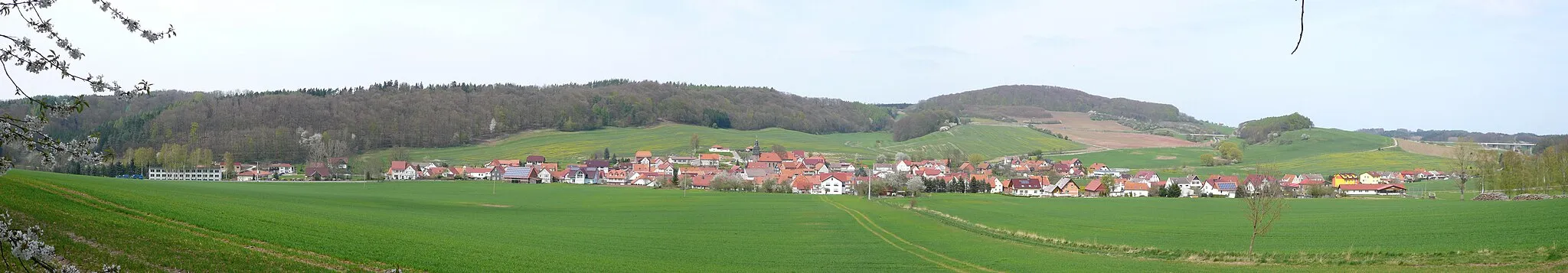 Photo showing: Blick vom Rusteberg auf Rustenfelde im Eichsfeld (der Bergkamm von links: Mühlberg, Höllberg und Rohrberg)