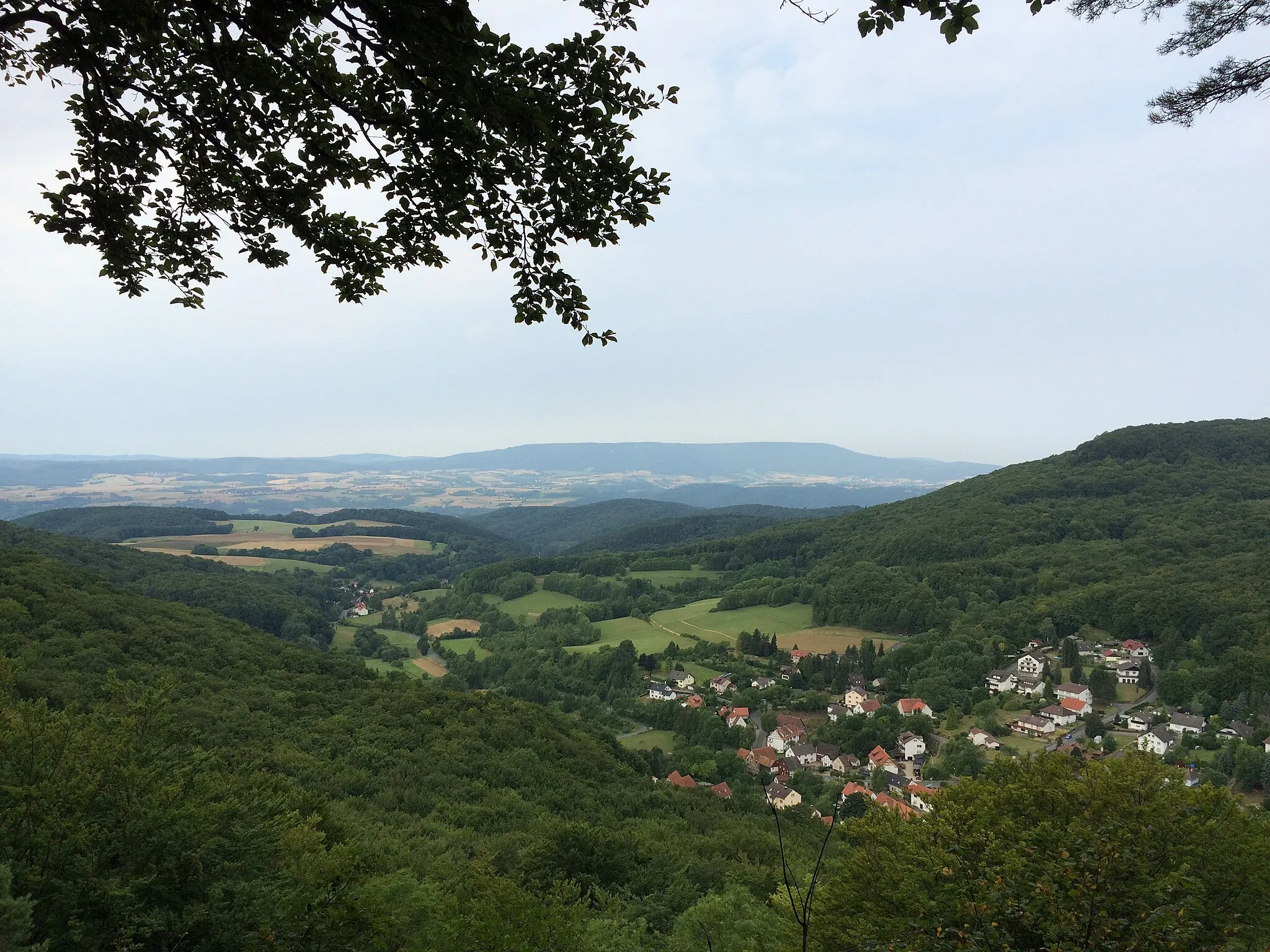 Photo showing: Aussichtspunkt Wolfstisch (471 m) am Werra-Burgen-Steig Hessen (X5H) mit Blick auf Hitzelrode (Meinhard), rechts die Hohe Bahn am Hohestein