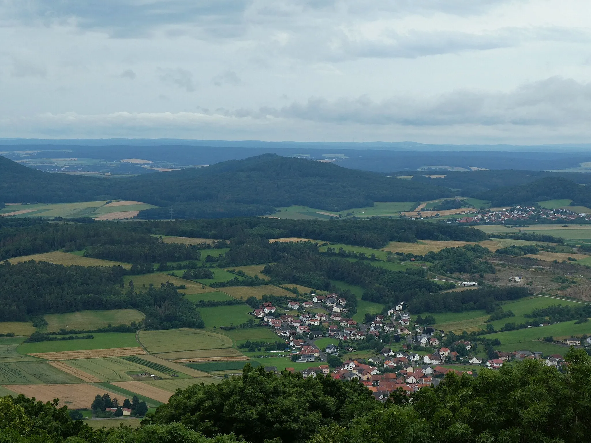 Photo showing: Blick vom Soisbergturm zum Rückersberg (Hessisches Kegelspiel). Die Ortschaft rechts unterhalb der Bildmitte ist Ufhausen. Rechts unterhalb der Rückersbergs der Orts Leibolz.