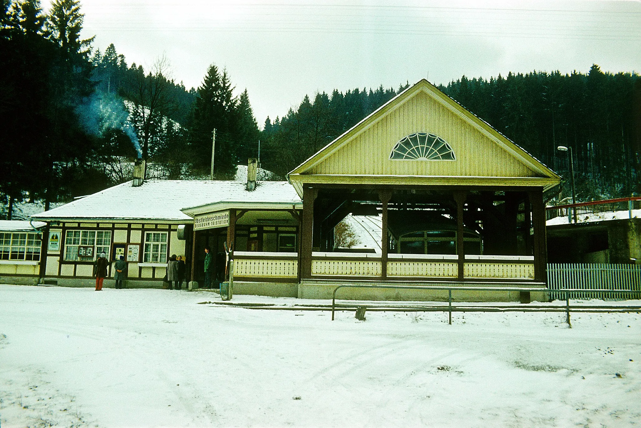Photo showing: Die Talstation der Seilbahnstrecke der Oberweißbacher Bergbahn im Januar 1981, der Bahnsteig des Haltepunktes Obstfelderschmiede der Schwarzatalbahn (6)690 Rottenbach–Katzhütte liegt davor.