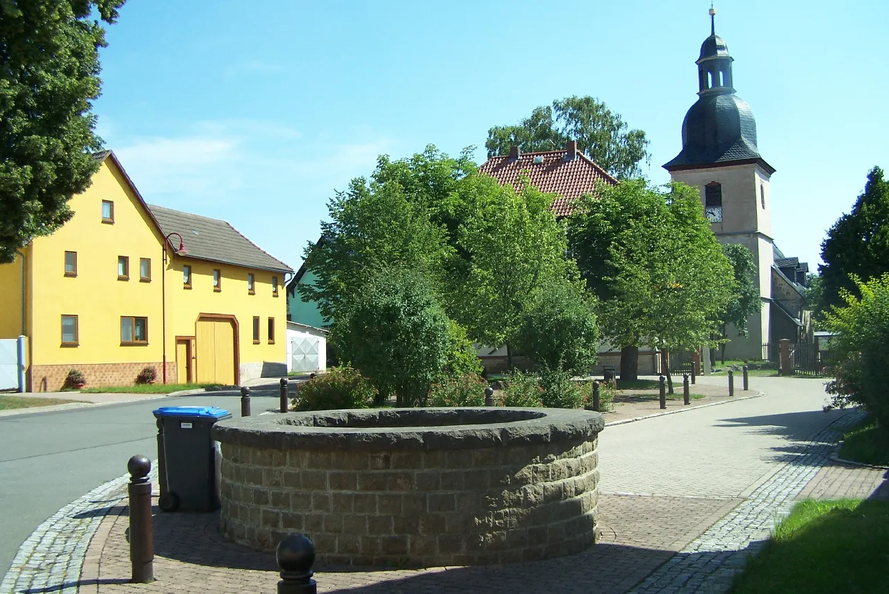 Photo showing: Der Dorfplatz mit Kirche und Brunnen in Reichenbach (Hörselberg-Hainich).
