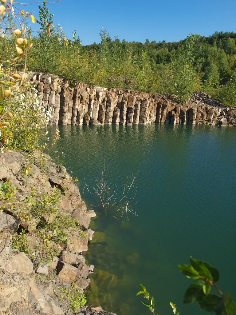 Photo showing: At stone pit on the mountain Nöll in Knüllgebirge. Part of a lake and columnar basalts