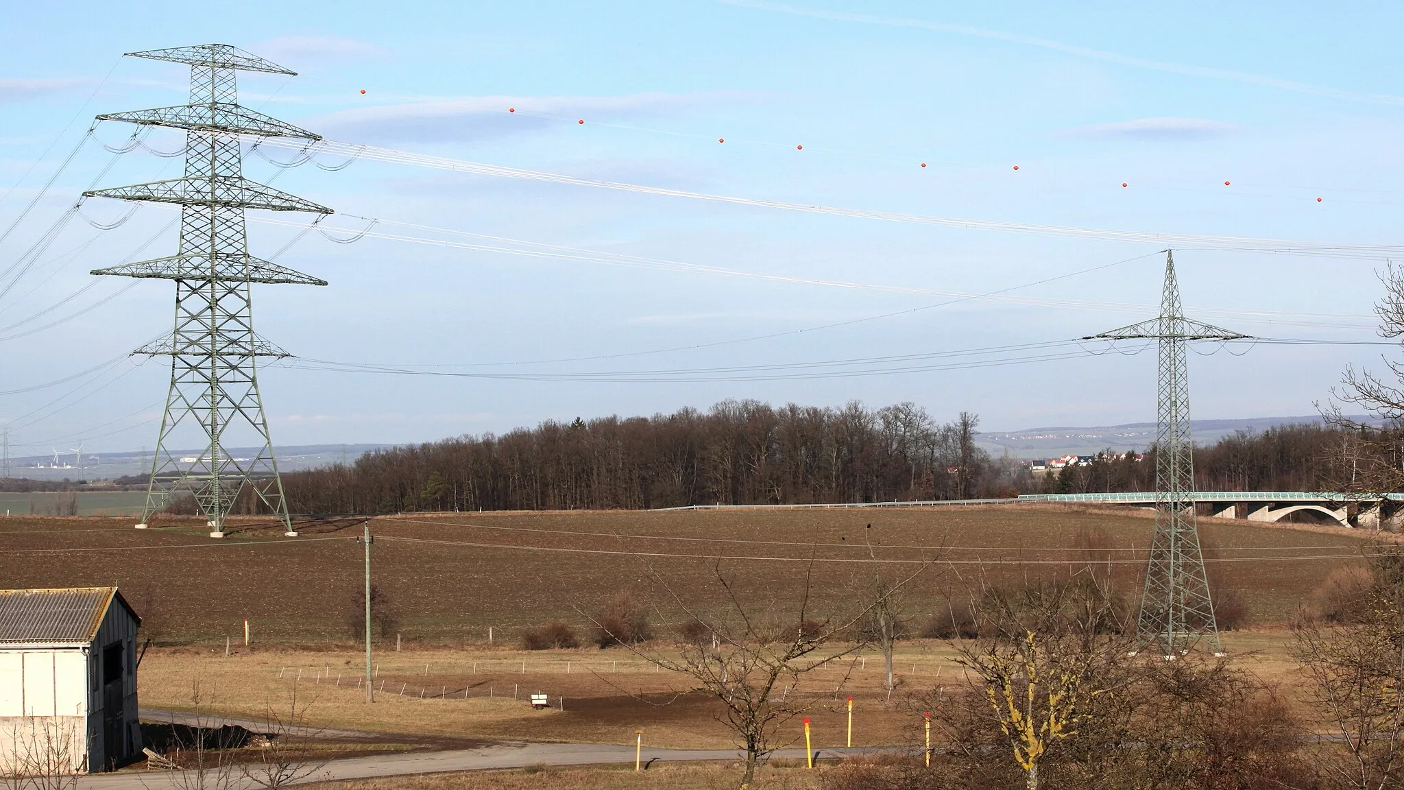 Photo showing: Thüringer Strombrücke (380 kV) bei Branchewinda (Thüringen), Hybridmast mit zusäzlicher Traverse für zwei weitere 380-kV-Stromkreise und Traverse mit 110-kV-Bahnstromleitung (Eischleben—Altenfeld)