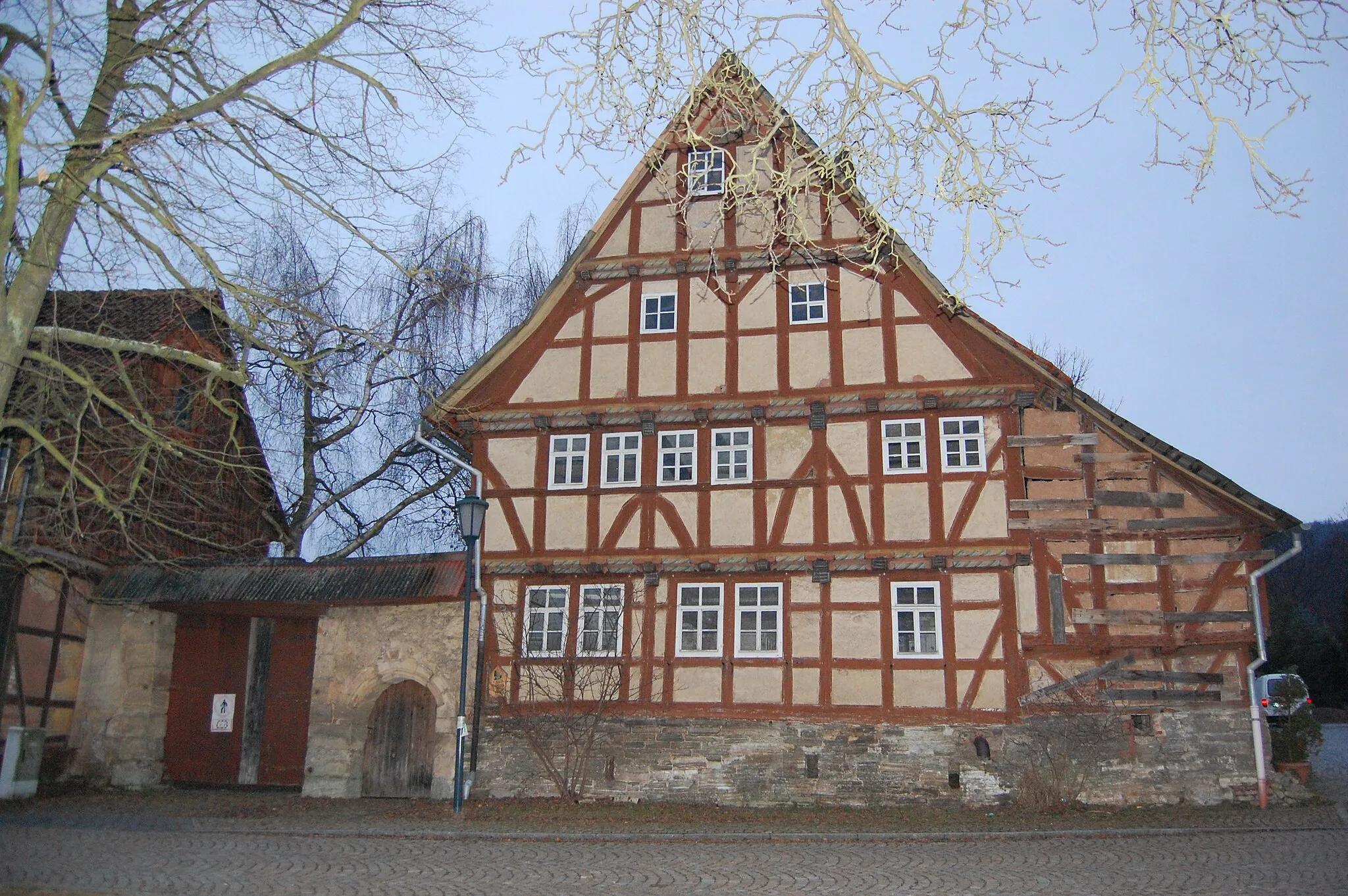 Photo showing: Denkmalgeschütztes Fachwerkhaus (gebaut um 1589) in Hauröden, Eichsfeld, Thüringen, Deutschland – Das Gebäude ist für das Eichsfeld einzigartig und steht auf der Liste der deutschlandweit 200 bedeutendsten denkmalgeschützten Fachwerkhäuser.
Im Inneren befindet sich ein offener Kamin mit der Jahreszahl 1593. Eine wissenschaftliche Analyse der Eichenbalken bestätigte das Alter des Hauses (Baumfällung im Winter 1592).

Eine zum Gebäude angefertigte Diplomarbeit brachte einen besonderen Aspekt zutage, der die geschichtliche Bedeutung des Hauses in ein neues Licht rückt: Der Burghauptmann der Wartburg bei Eisenach, Hans v. Berlepsch, bekam als Lohn für die Organisation der Entführung und den Schutz Martin Luthers während der Bibelübersetzung ein beträchtliches Vermögen. Dieses übertrug er seinen Kindern, die davon unser Herrenhaus in Hauröden errichten ließen.