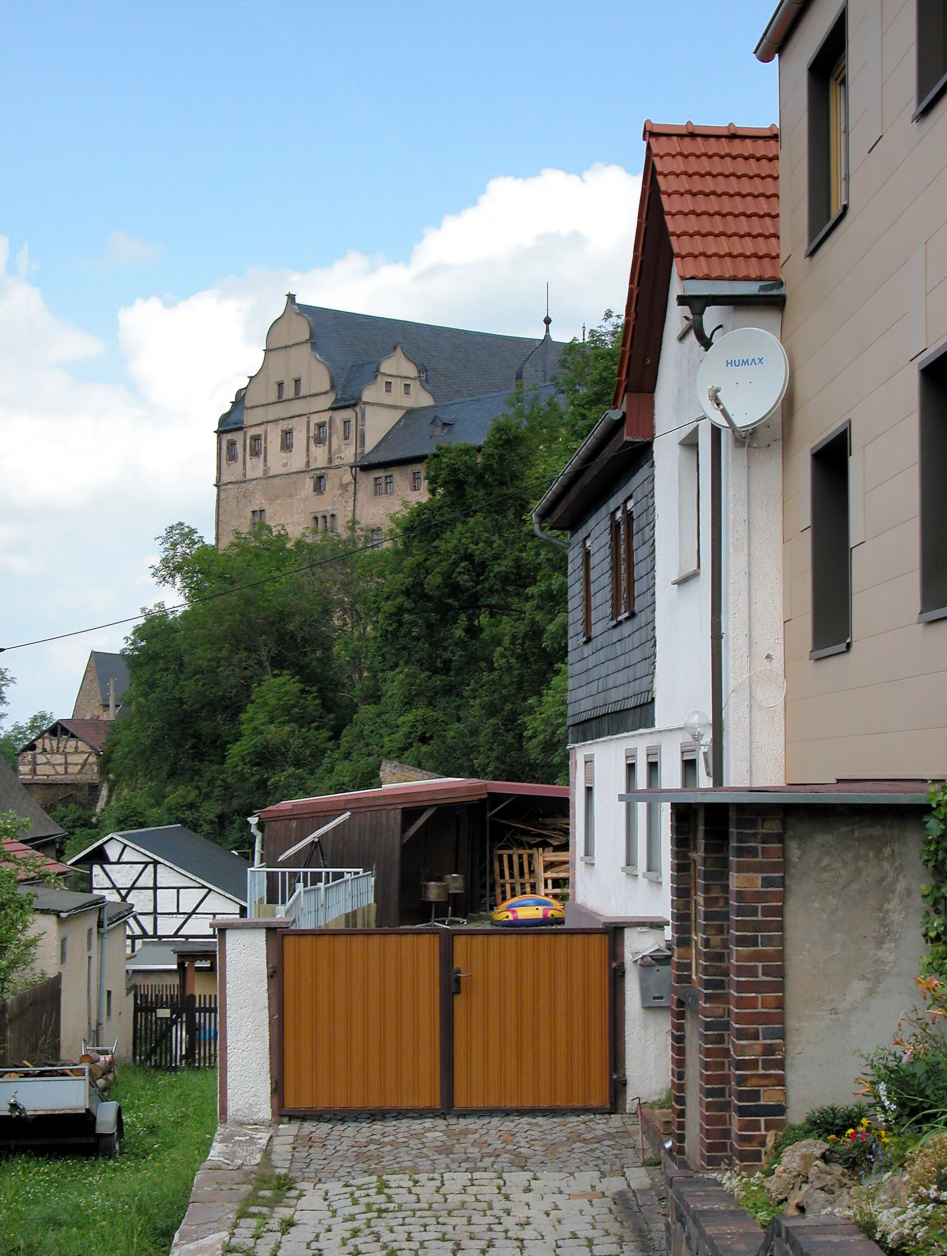 Photo showing: 04.07.2012    07333  Könitz (Unterwellenborn), Schloßberg 16: Schloß (GMP: 50.651241,11.489464). Um 800 begann der Bau der Burganlage durch einen Ritter von Conz. Von seinem Namen leitet sich auch der Name des Adelsgeschlechts Könitz ab. Die  Burg ist eine 1438 urkundlich genannte, unregelmäßige Anlage. 1562 wird der Bau des Schlosses in seiner noch heute zu sehenden Form vollendet. Im Westen und Süden je ein Flügel, im Osten mächtiger Bergfried, im Hof Treppenturm mit reichem spätgotischem Balkon, im Westflügel Remter mit Balkendecke. 1608 fällt das Schloss an die Grafen von Schwarzburg-Rudolstadt. In der DDR-Zeit dient das Schloß seit 1955 als Unterkunft für geistig behinderte Menschen / Feierabendheim. Es wird heute [... 2012] von der Arbeiterwohlfahrt Saalfeld-Rudolstadt geführt. Sicht von Südosten.  [DSCNn4221.TIF]20120704060DR.JPG(c)Blobelt