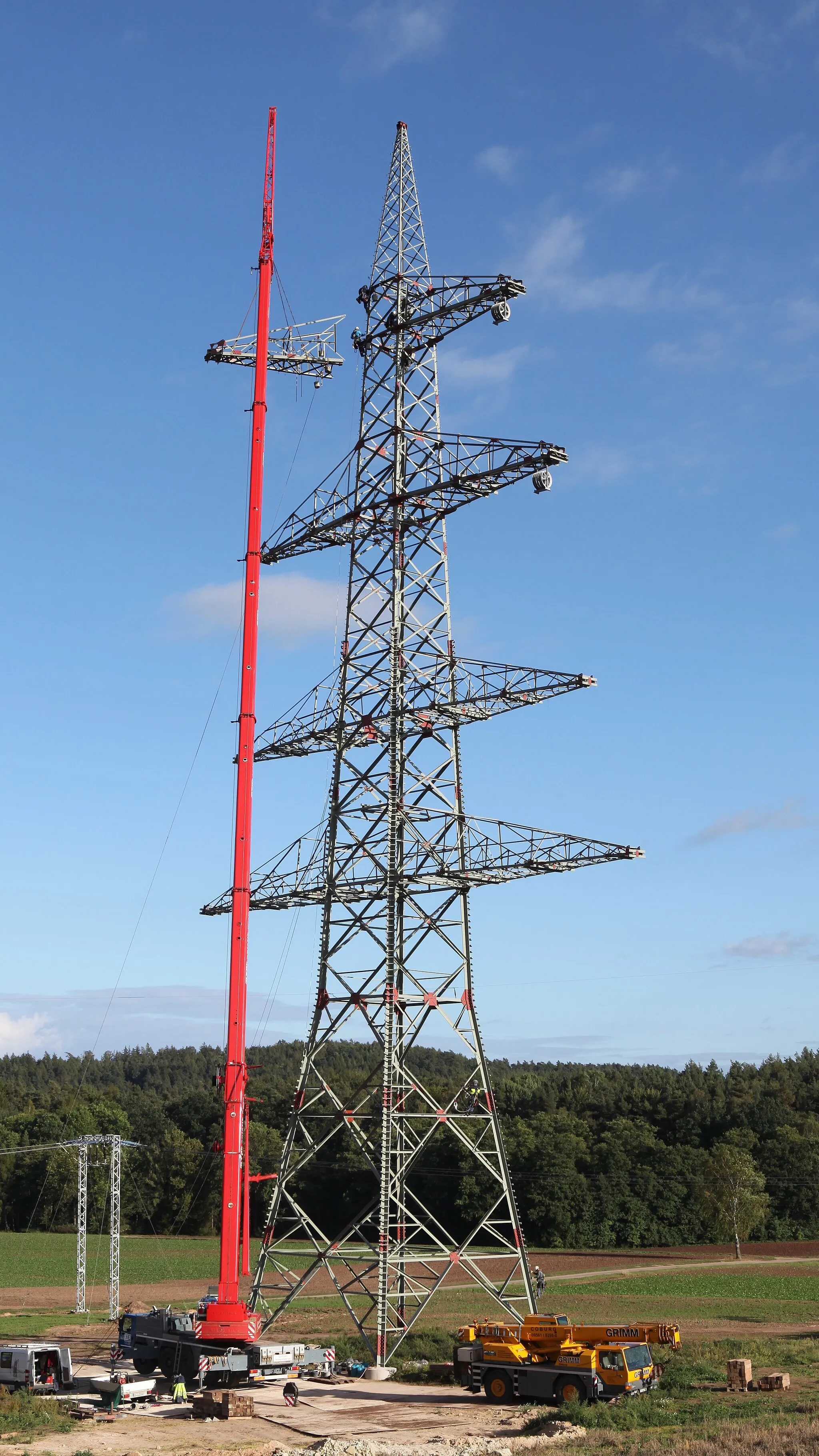 Photo showing: Thüringer Strombrücke (380 kV) bei Neu- und Neershof (Coburg, Bayern), Montage Winkelabzweigmast mit zusäzlicher Traverse für Anschluss 110-kV-Leitung nach Neustadt bei Coburg; links Provisorium