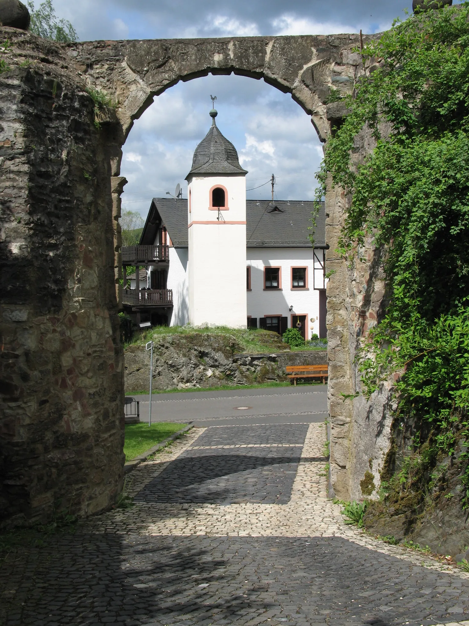 Photo showing: Blick aus dem Tor der Ruine der Burg Dhronecken auf den Glockenturm der Gemeinde. Fotografiert und zur Veröffentlichung freigegeben von Reinhold Anton aus Thalfang.