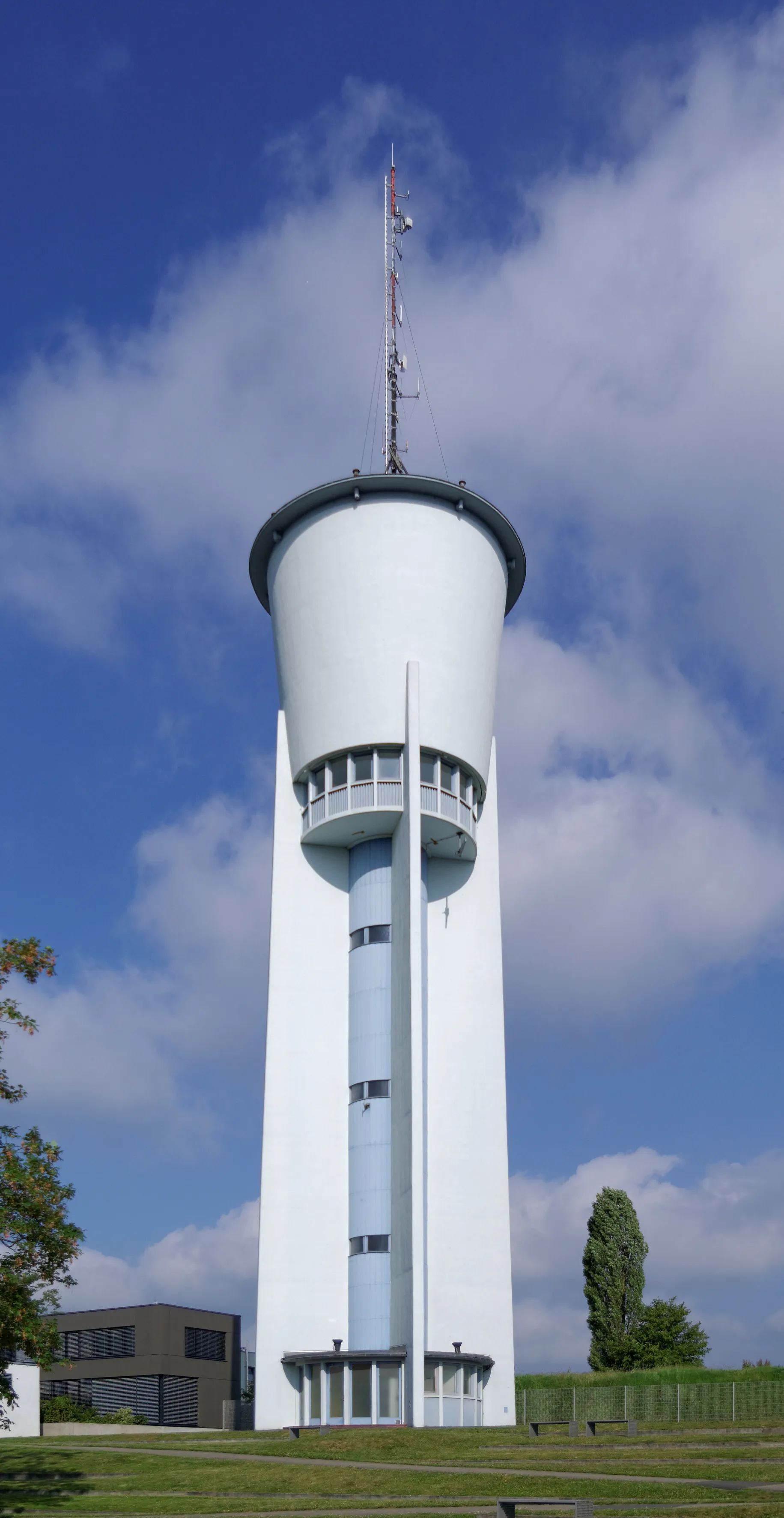 Photo showing: Trier, Sickingenstraße ohne Nummer: Wasserturm; 1958 nach Plänen des Trierer Architekten Herbert Montebaur als Stahlbetonkonstruktion für die Wasserversorgung der französischen Militäranlagen auf dem Petrisberg errichtet, sich nach oben konisch erweiternde Hochbehälter mit flachem, leicht überstehendem Dach von vier strebepfeilerartigen Betonscheiben um einen runden Kern gestützt