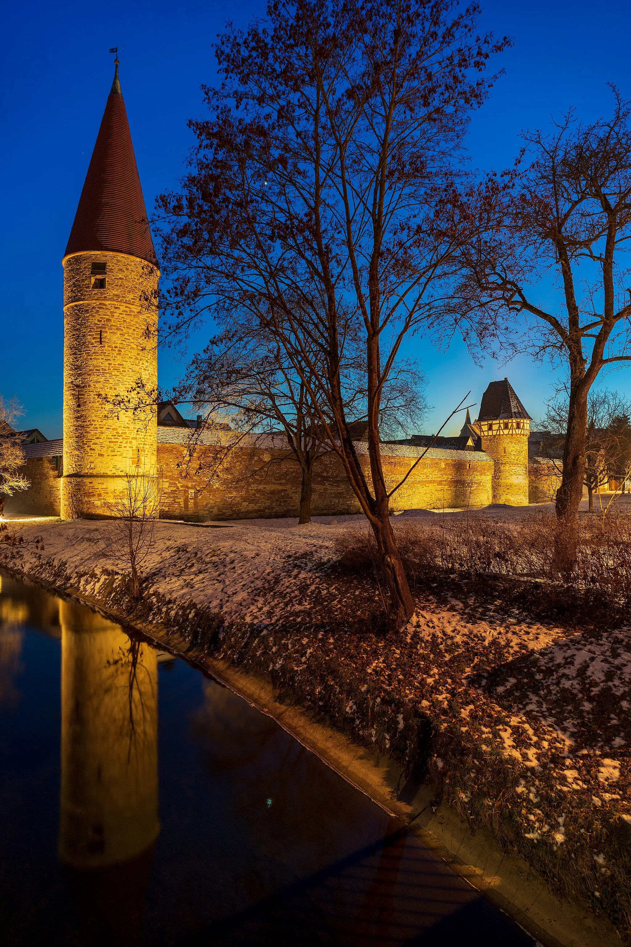 Photo showing: Weil der Stadt, Germany: north-east part of the medieval town wall, the Roter Turm (“Red tower”, left) and the Storchenturm (right). At the bottom left the river Würm. Photo taken in the blue hour from the bridge over the river Würm.
