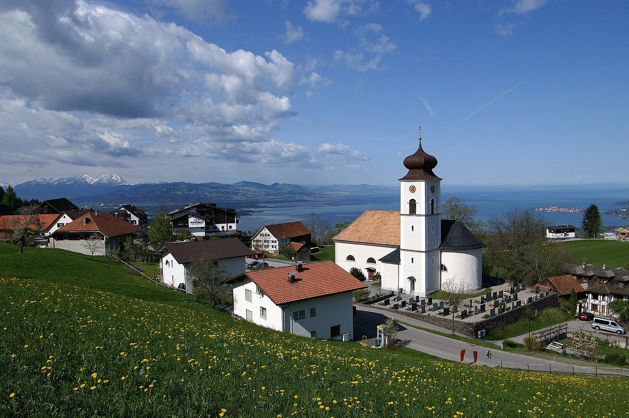 Photo showing: Overlooking the St. Bernard Parish Church at Eichenberg (Vorarlberg), of Lake Constance and the Swiss mountains of Alpstein. Right in the picture: Lindau.