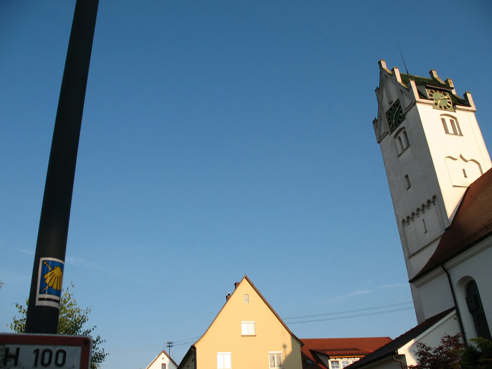 Photo showing: Ein Jakobsweg- Wegweiser in Form der typischen Muschel und die Kirche.