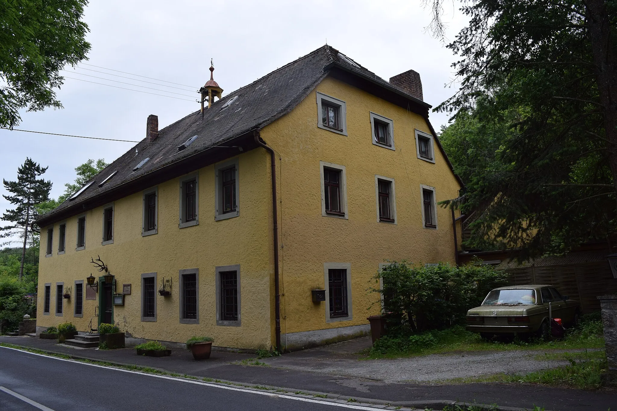 Photo showing: Blick von Nordwest auf das heute als Gaststätte genutzte ehemalige Forsthaus im Guttenberger Wald, an welchem noch eine Inschriftentafel aus dem 16. Jahrhundert an ein abgegangenes Jagdschloss erinnert.