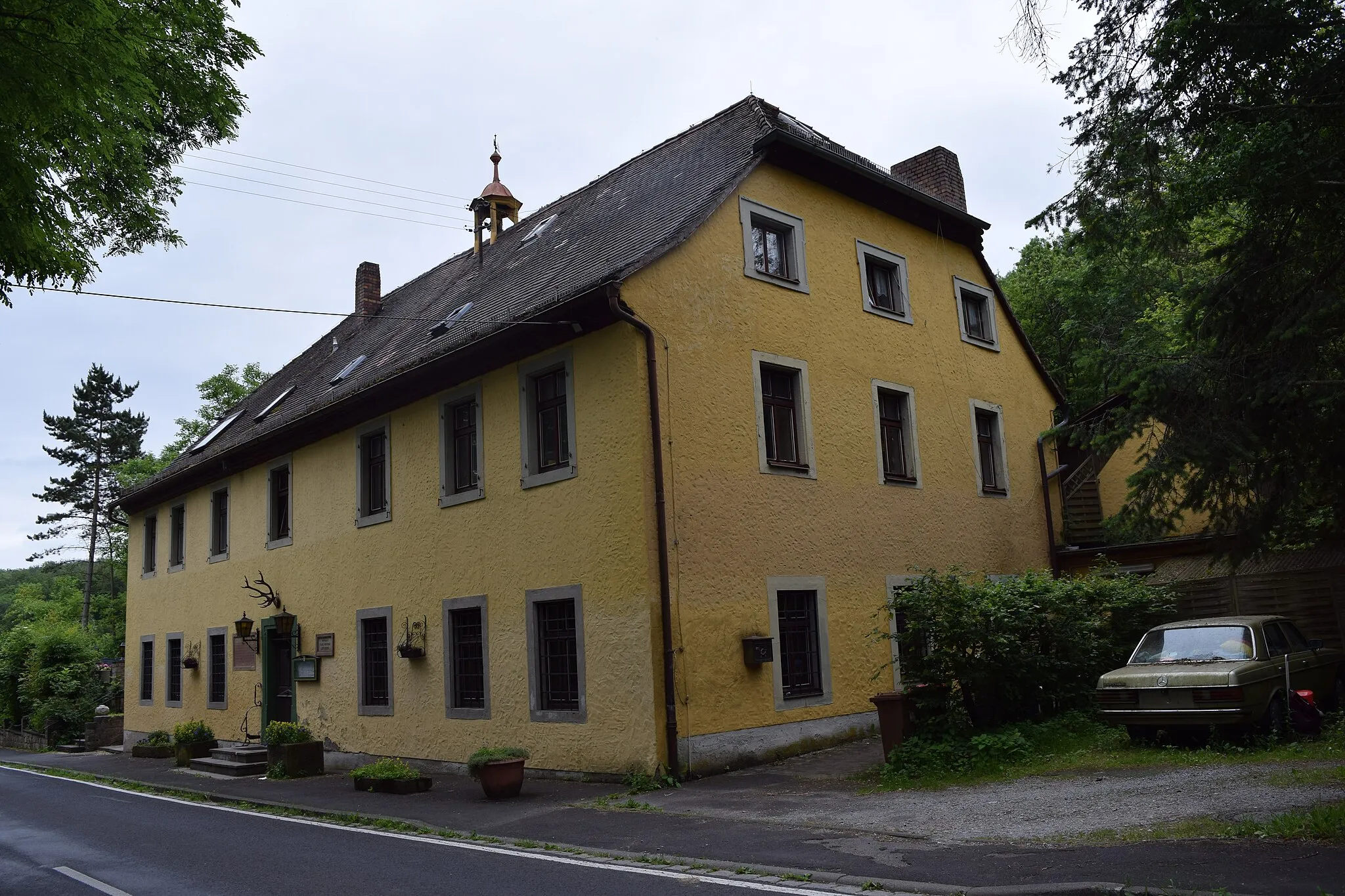 Photo showing: Blick von Nordwest auf das heute als Gaststätte genutzte ehemalige Forsthaus im Guttenberger Wald, an welchem noch eine Inschriftentafel aus dem 16. Jahrhundert an ein abgegangenes Jagdschloss erinnert.