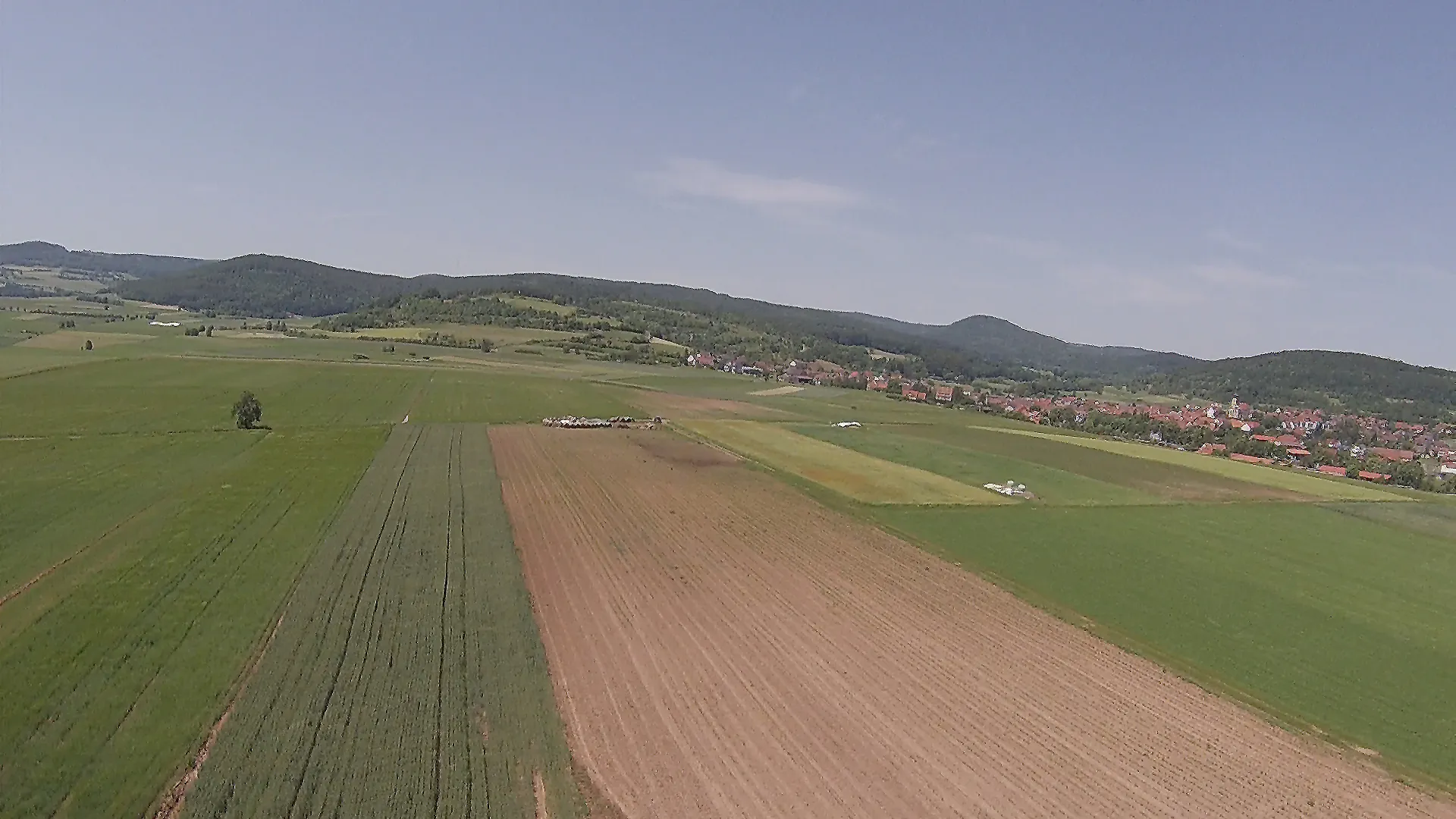 Photo showing: Blick aus westsüdwestlicher Richtung über die Feldflur beim Ort Oberelsbach (rechts) auf den Dünsberg (mit dem Naturschutzgebiet „Dünsberg“, NSG-00537.01, am Osthang); gesamter Bildbereich im Naturpark Bayerische Rhön