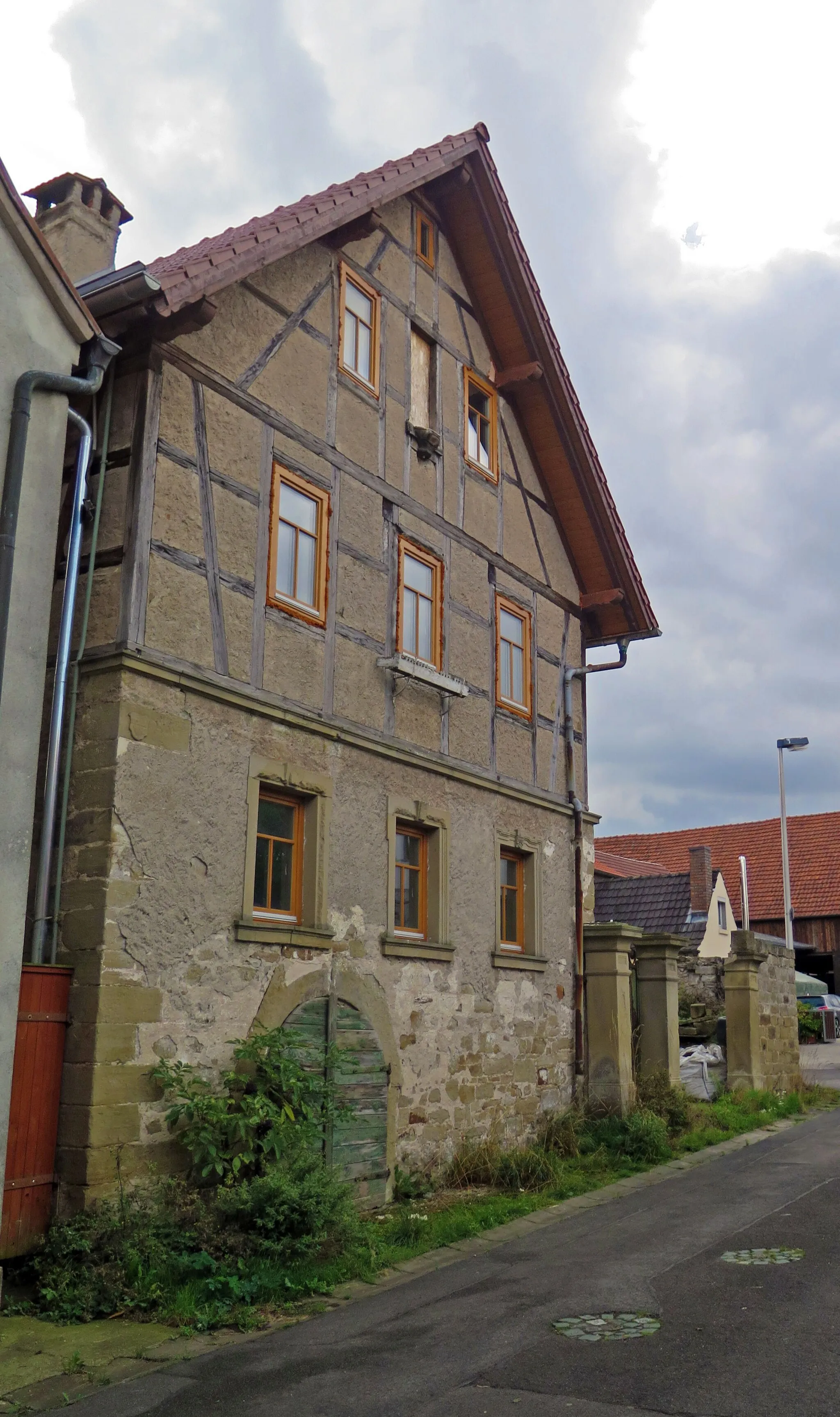 Photo showing: Former farmhouse, two-storey and gable settled gabled roof construction on high basement, with half-timered upper floor and ear-type window frames, 18th/19th century, with older core, labelled 1600