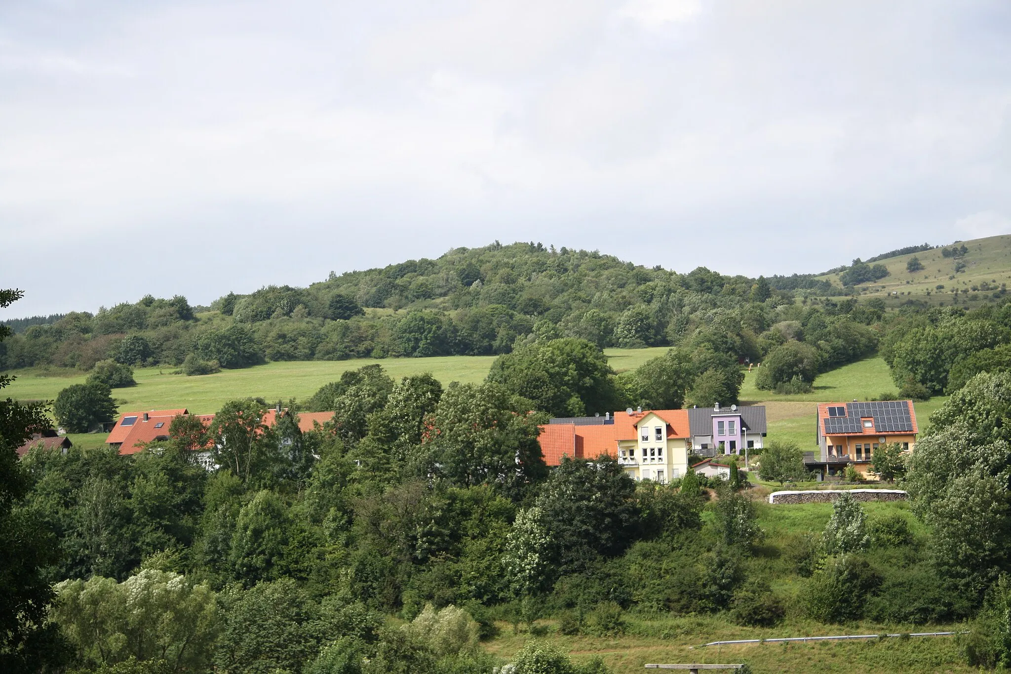 Photo showing: Blick von Süden über die Häuser von Oberweißenbrunn zum Rockenstein. Rechts die Westflanke des Himmeldunkbergs