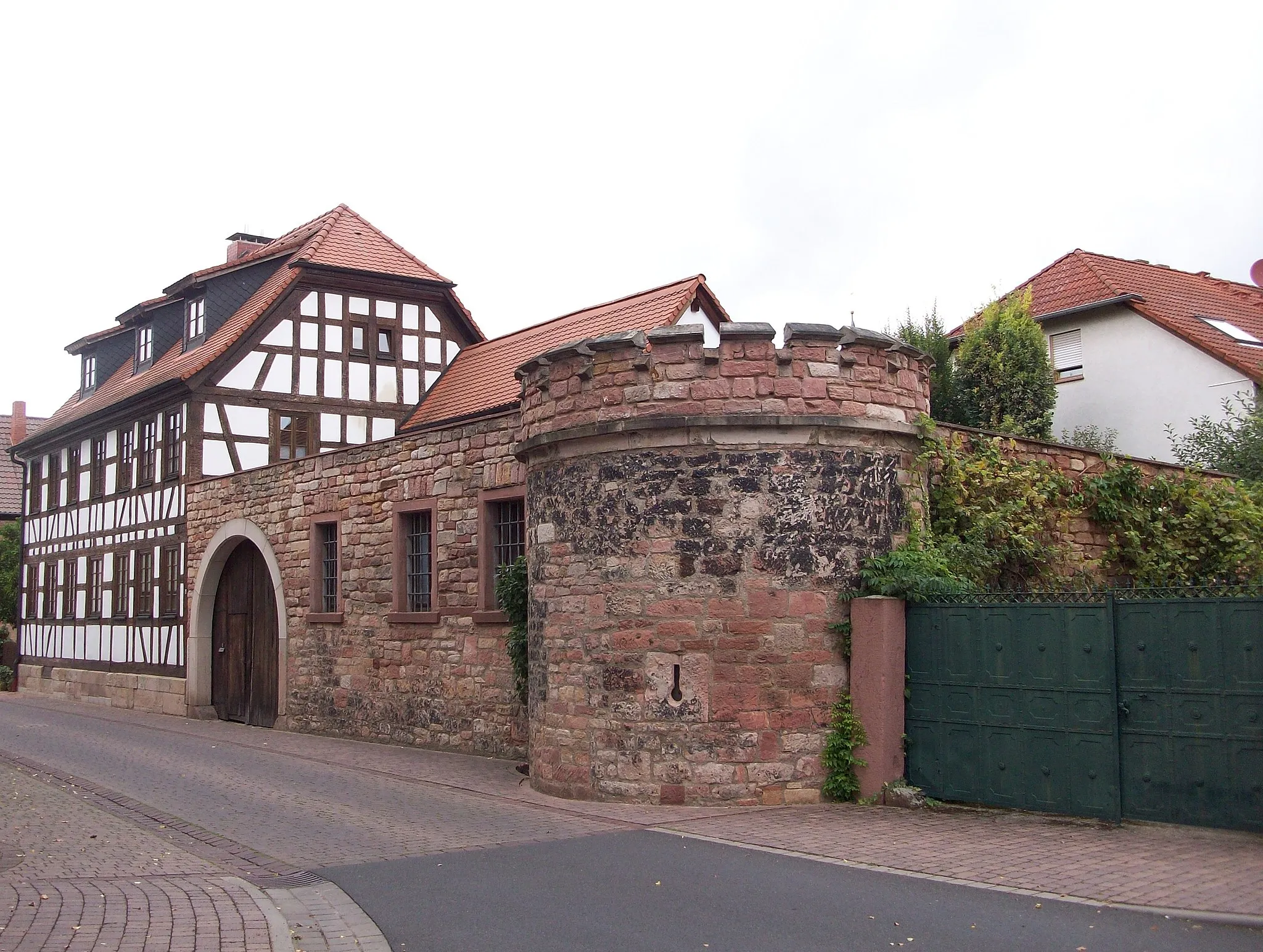 Photo showing: Stadtmauerrest mit Eckturm in Kleinwallstadt an der Ecke Obere Straße - Landesstraße 2309,mit Zinnen, 15./16. Jahrhundert, This is a photograph of an architectural monument. It is on the list of cultural monuments of Kleinwallstadt, no. D-6-76-133-21.