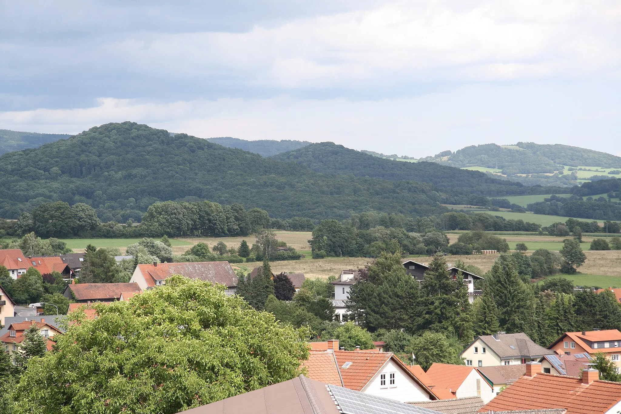 Photo showing: Blick über die Ortslage von Oberleichtersbach ostwärts auf Platzer Kuppe (Südende der Schwarzen Berge), Lindenstumpf und Mettermich (Brückenauer Kuppenrhön), Franken