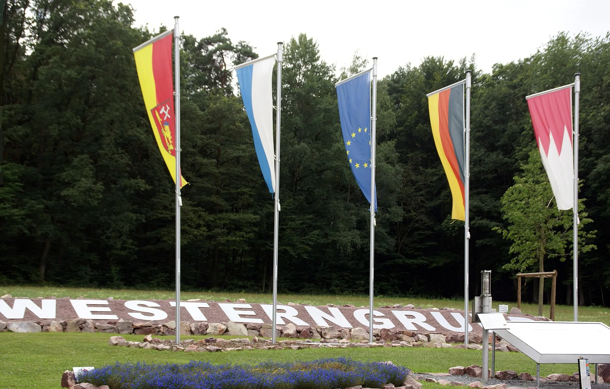 Photo showing: Westerngrund, Kahler Straße: flags of Westerngrund, Bavaria, European  Union, Federal Republic of Germany and Lower Franconia (from left) at the geodetic centre of the European Union