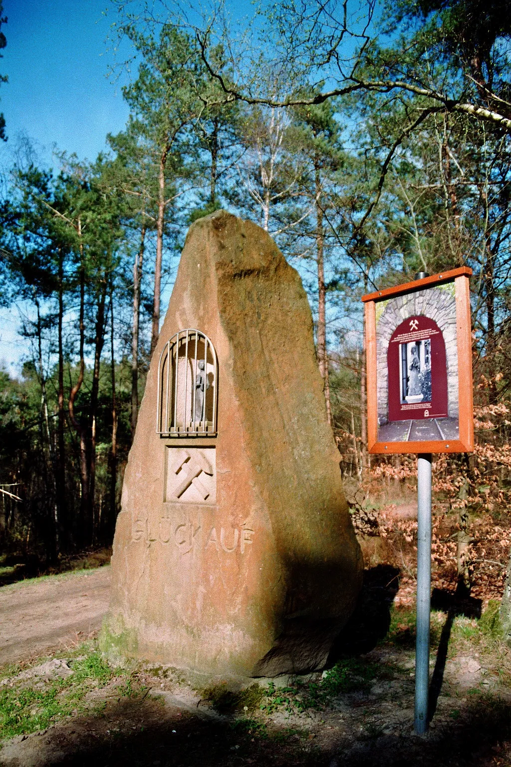 Photo showing: Barbara-Gedenkstein am Buchholzer Förderturm, Aussichtsturm im Buchholzer Forst in Recke-Steinbeck, Kreis Steinfurt, Nordrhein-Westfalen, Deutschland. Die in dem Stein befindliche Statue der Heiligen Barbara als Schutzpatronin der Bergleute schuf der Bildhauer Werner Klenk. Mit diesem im Jahr 2005 eingeweihten Erinnerungsstein gedenkt der Bergbauhistorische Verein Buchholzer Forst 1650 Recke e.V. "der Toten und Verletzten bei der schweren Arbeit in den Buchholzer Grubenfeldern und im gesamten Ibbenbürener Kohlenrevier", wie es auf der rechts neben dem Stein aufgestellten Erläuterungstafel heißt.