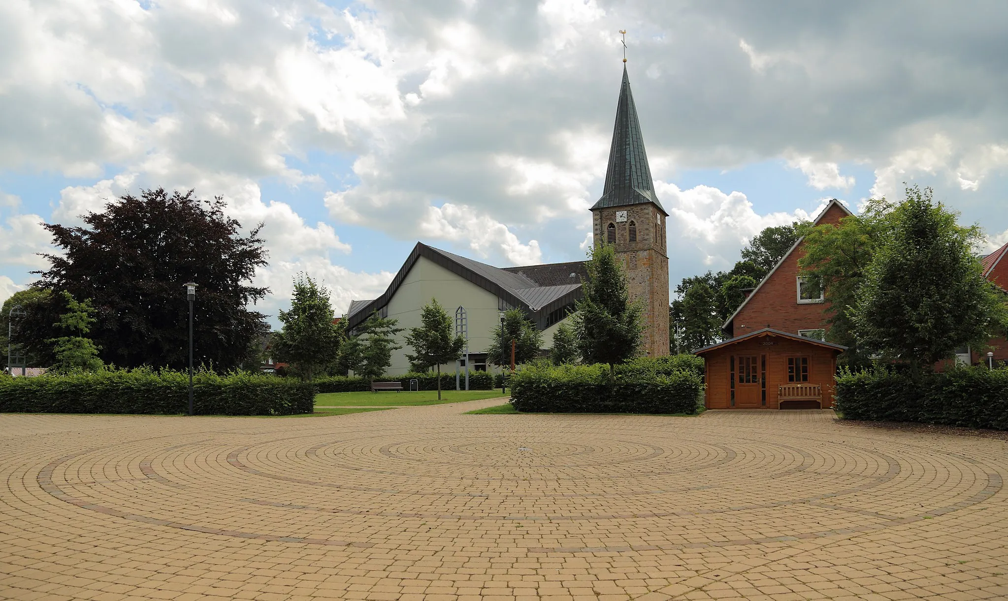 Photo showing: So called „Ecumenism Midst“ (Ökumenische Mitte) in Baccum, a city district of Lingen (Ems), Landkreis Emsland, Lower Saxony, Germany. The square is situated between the Reformed Church and the Roman Catholic St. Antonius Church.