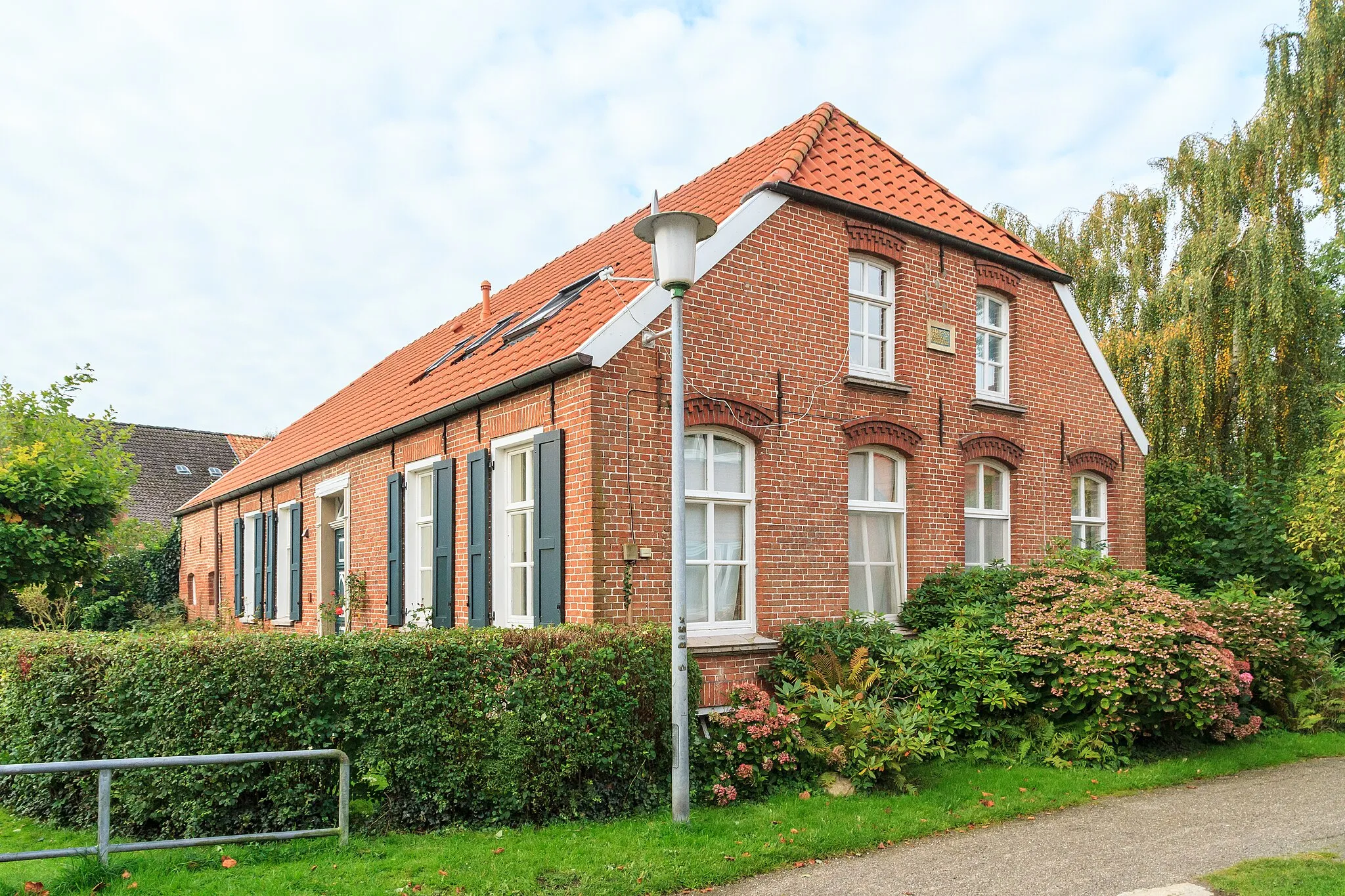 Photo showing: Neben der Kirche stehender, eingeschossiger Backsteinbau unter Halbwalmdach. Zum Teil Blockrahmen mit Schiebefenster sowie Eingang erhalten. Nordgiebel um 1900.