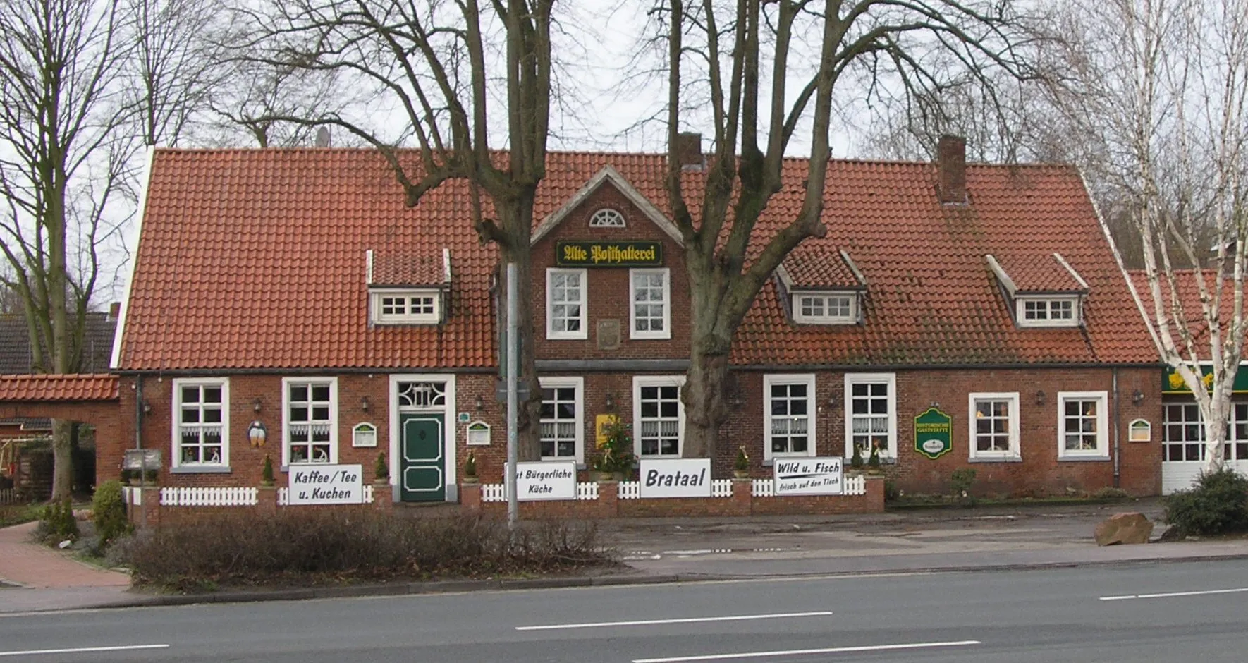 Photo showing: Alte Posthalterei in Hesel; vor dem Gebäude die Stämme der beiden als Naturdenkmal geschützten Linden