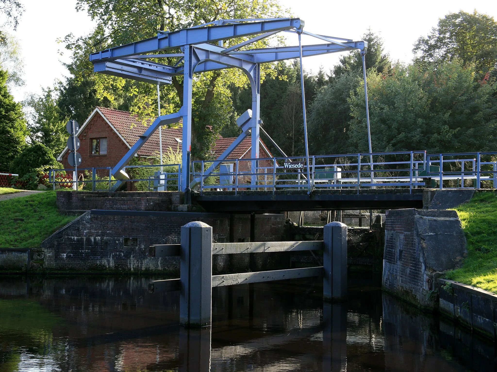 Photo showing: Denkmal Nr.35
Eiserne Klappbrücke holländischer Bauart über den Ems-Jade-Kanal. Diese schließt sich direkt an die Schleuse Wiesede an. Unter der Brücke sind die hölzernen Schleusentore zu erkennen.

Baujahr: um 1885
