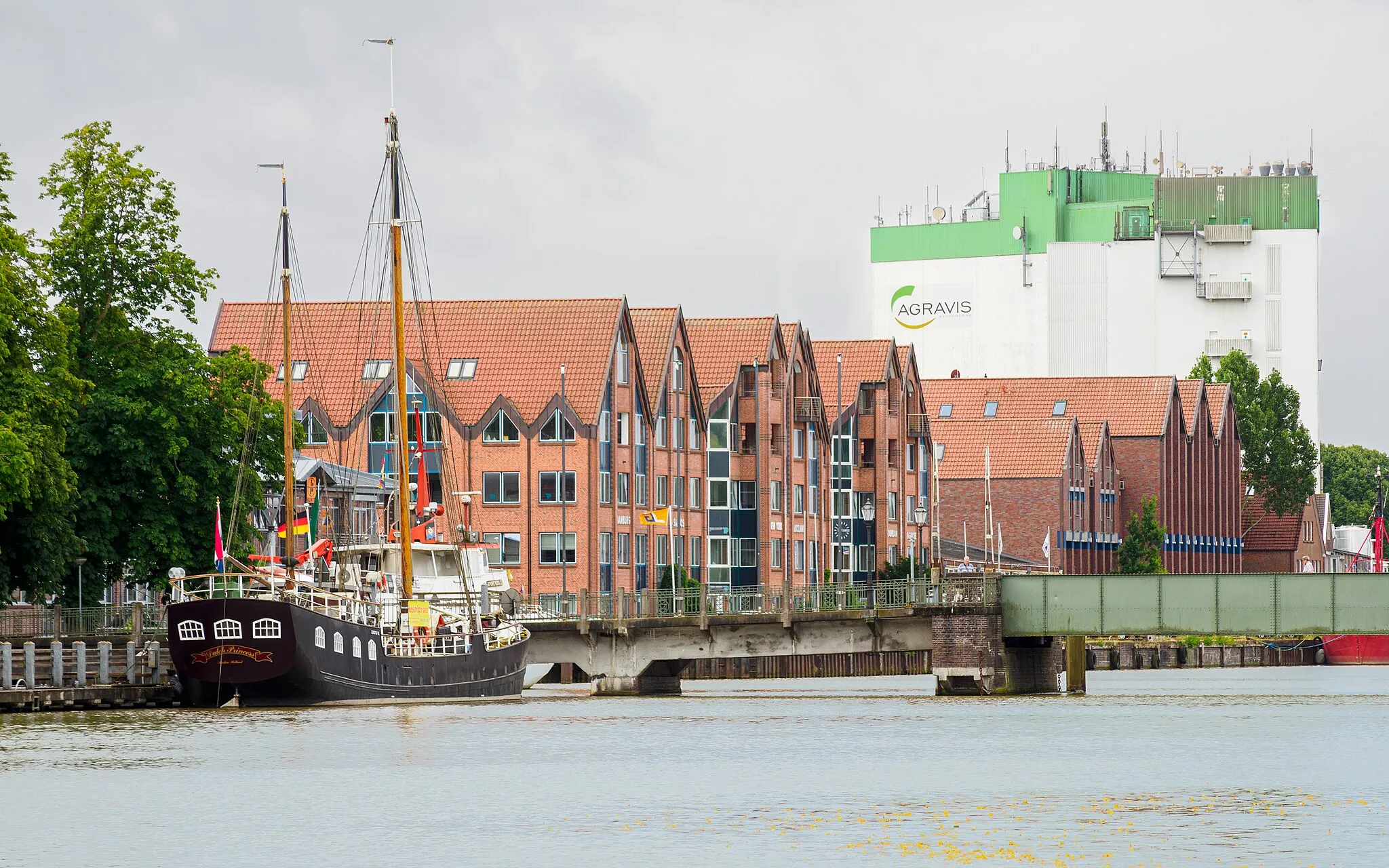 Photo showing: Leer (Ostfriesland): Freizeithafen/Handelshafen mit dem ehem. Frachtsegler "Dutch Princess" (30,6m / 144 t), der Dr.-vom-Bruch-Brücke, Bürogebäuden im Stile von Speicherhäusern und den Silos von Agravis Raiffeisen.