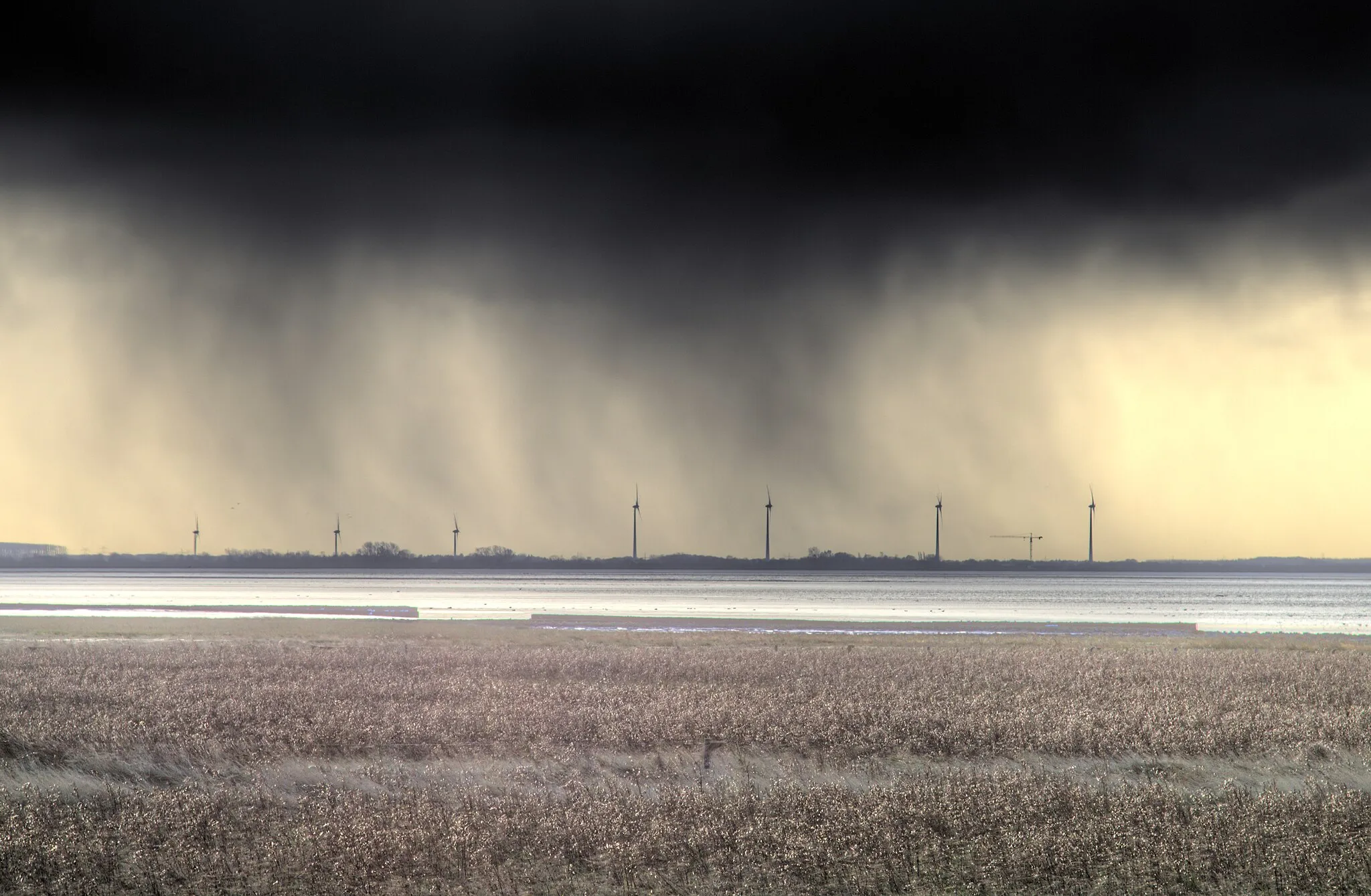 Photo showing: The southern part of the Jadebusen bay during the storm "Herwart", as seen from Sehestedt village (Jade municipality, Lower Saxony, Germany). The flood has already withdrawn from the forelands, yet fresh rainclouds are approaching again.