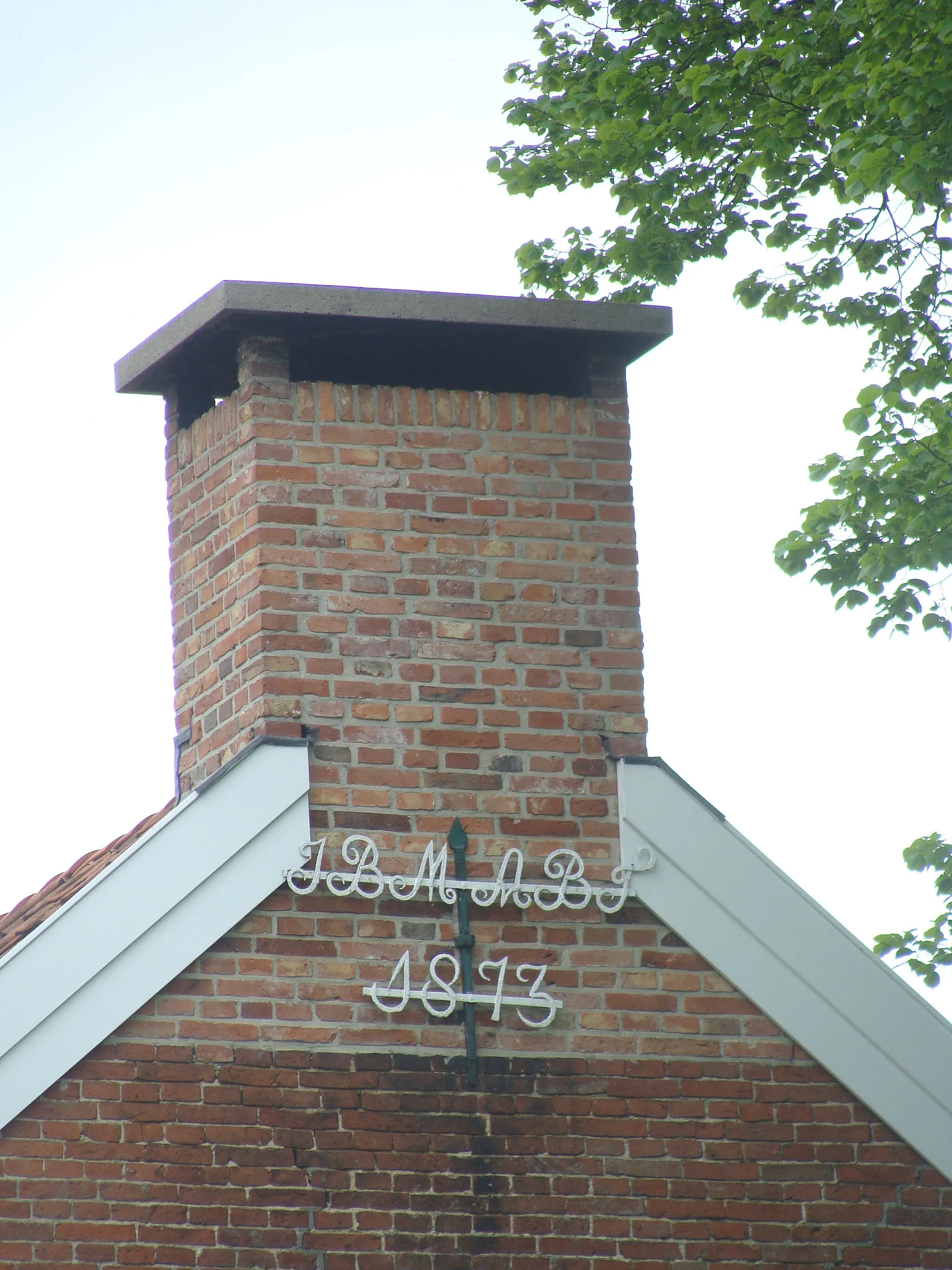 Photo showing: Detail of a farm in the Dutch Frisian village of Jipsinghuizen. Historical building, recognised as nl:rijksmonument. Chimney and wrought-iron piece with year.